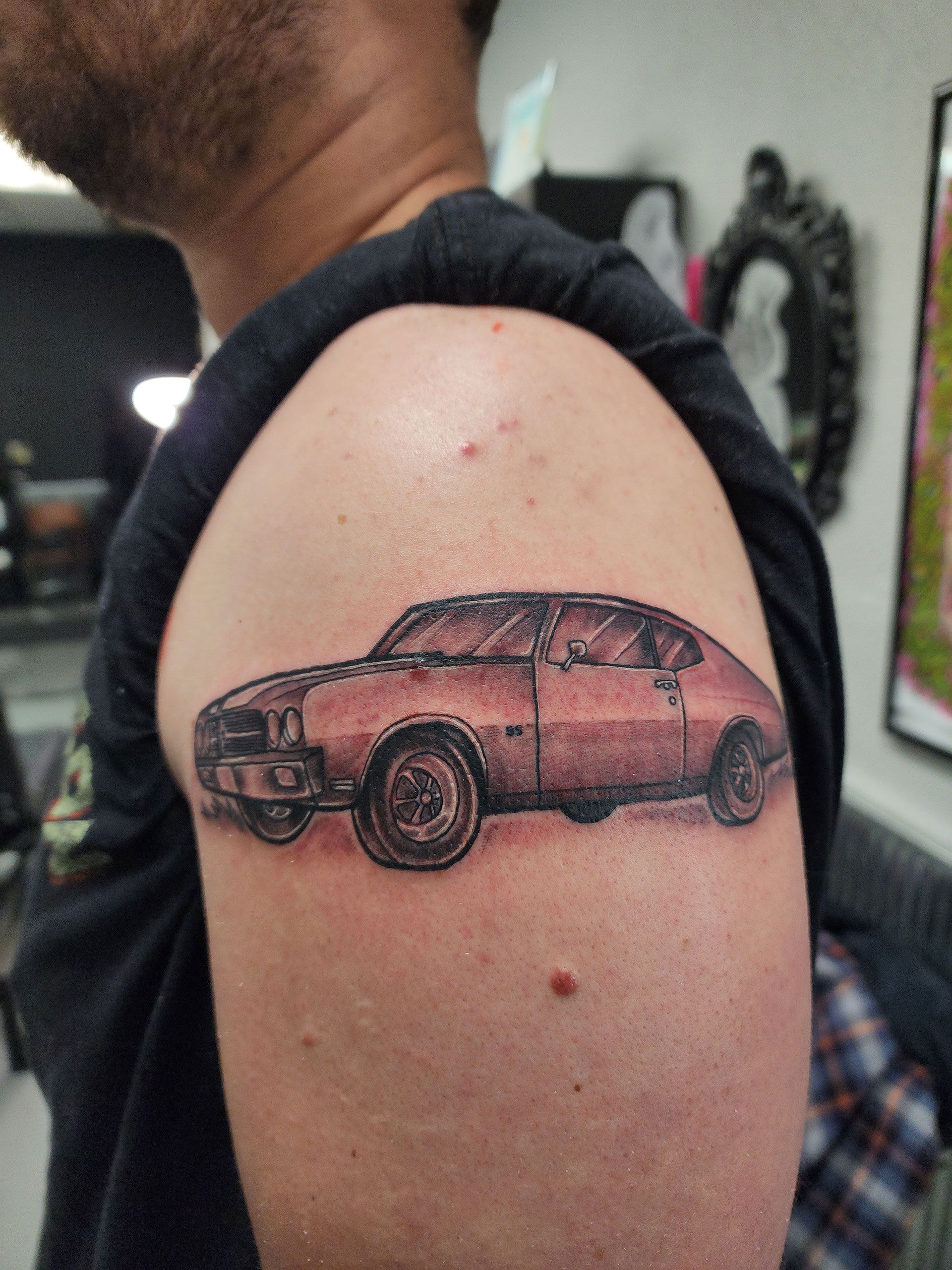 A man has a tattoo of a car on his arm
