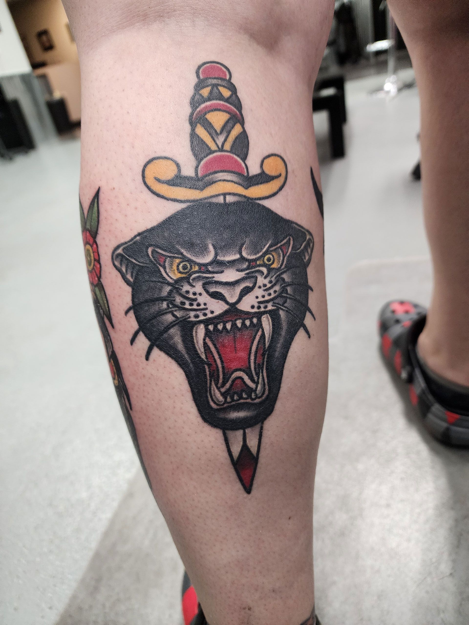 A tattoo of a panther with a dagger on its head