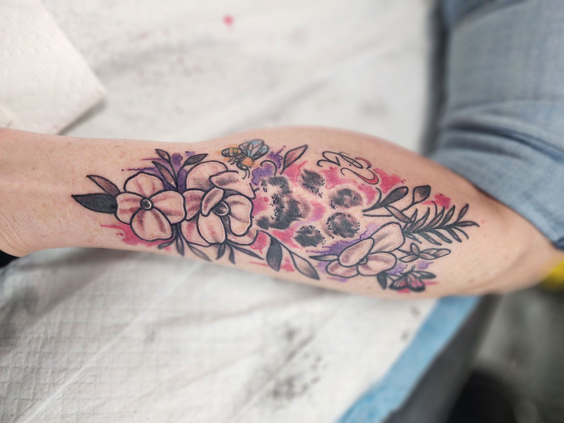 A person has a tattoo of flowers on their arm