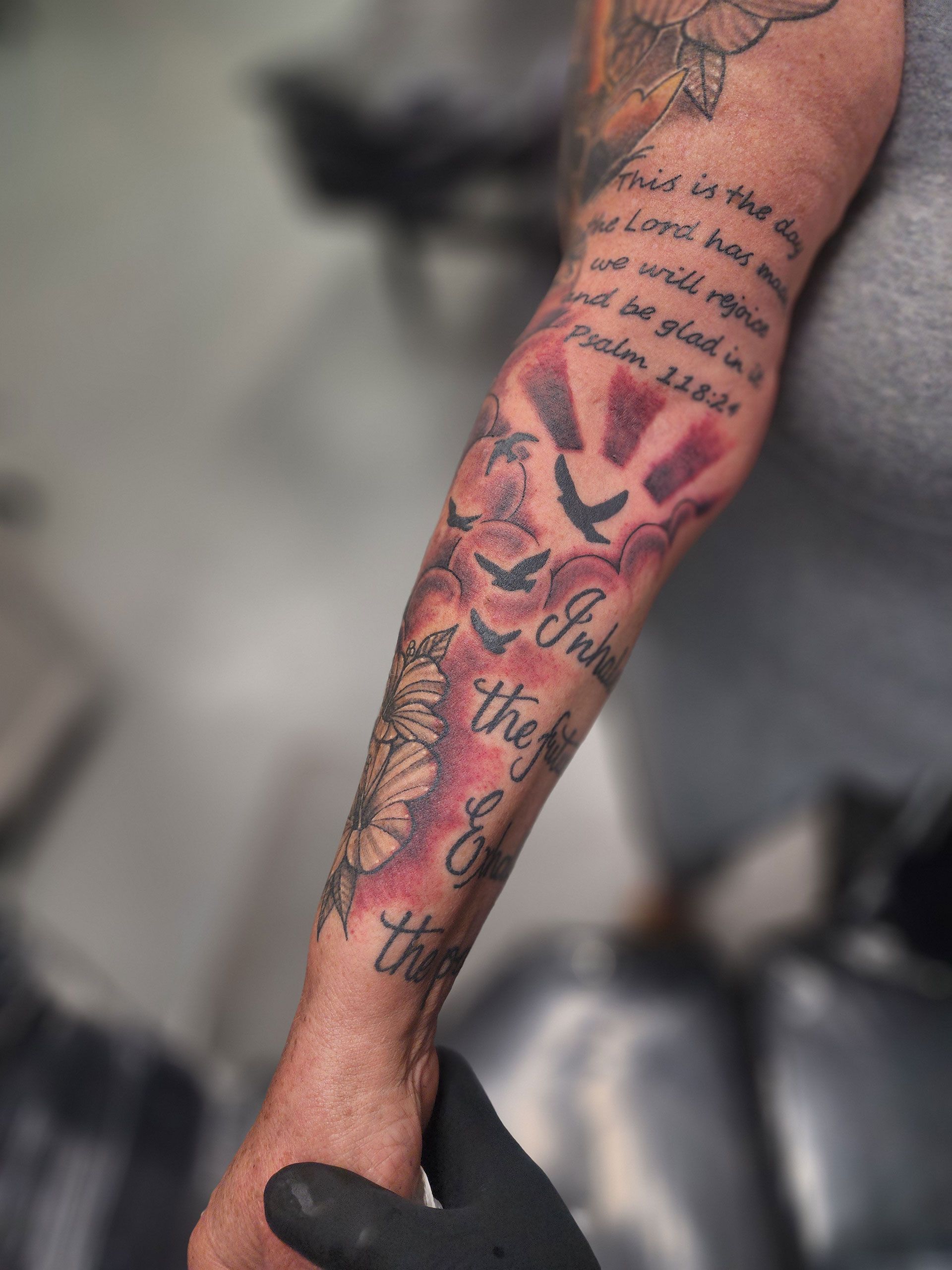 A man has a tattoo on his arm with 