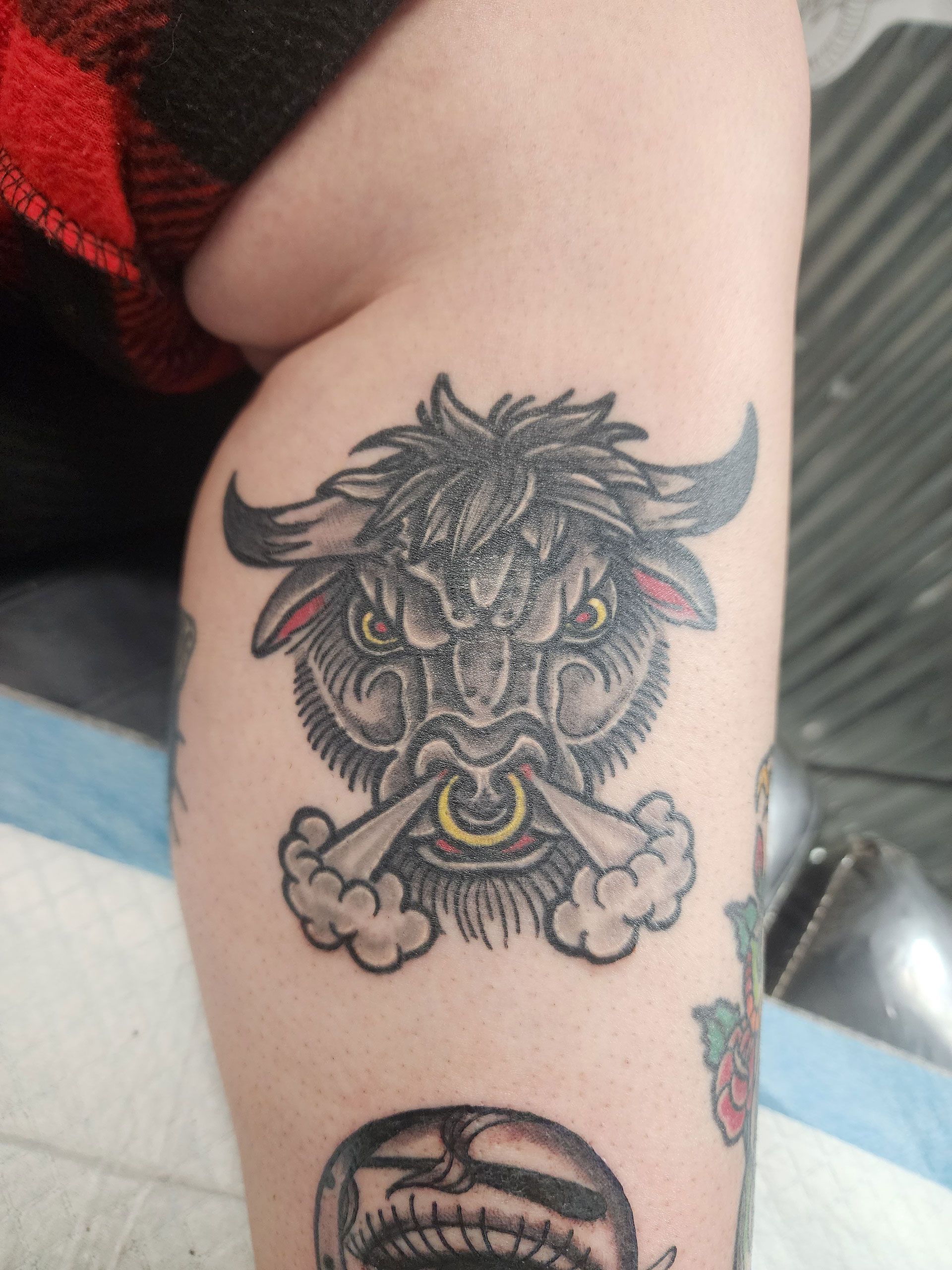 A person has a tattoo of a bull on their leg