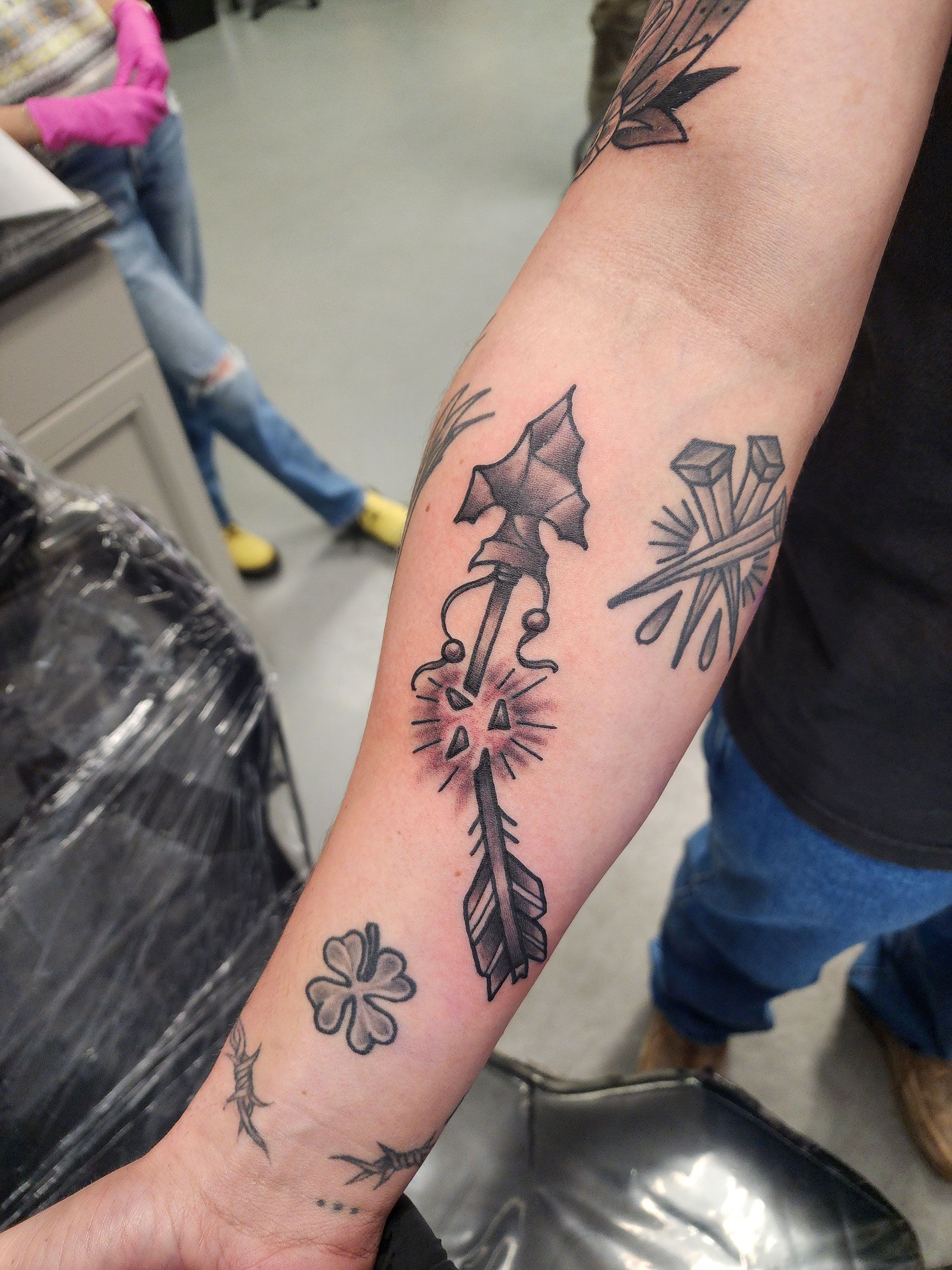 A person has a tattoo of broken arrow on their forearm