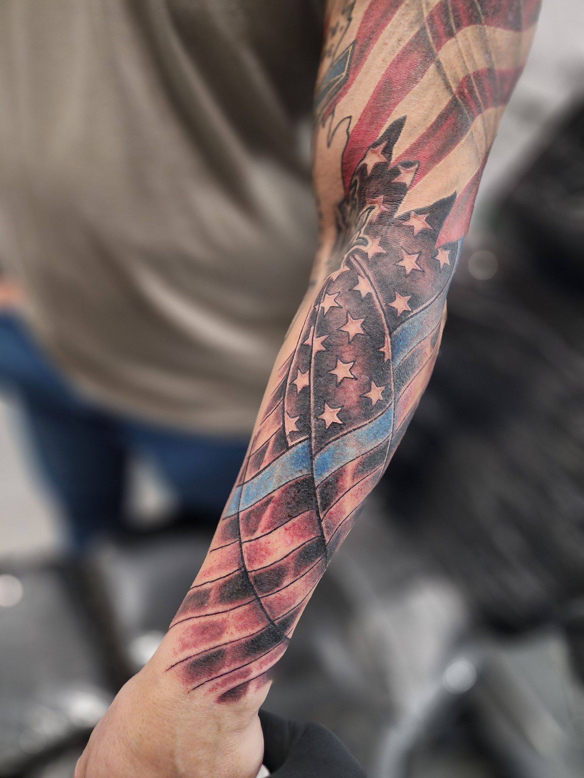 A man has a tattoo of an American flag on his arm