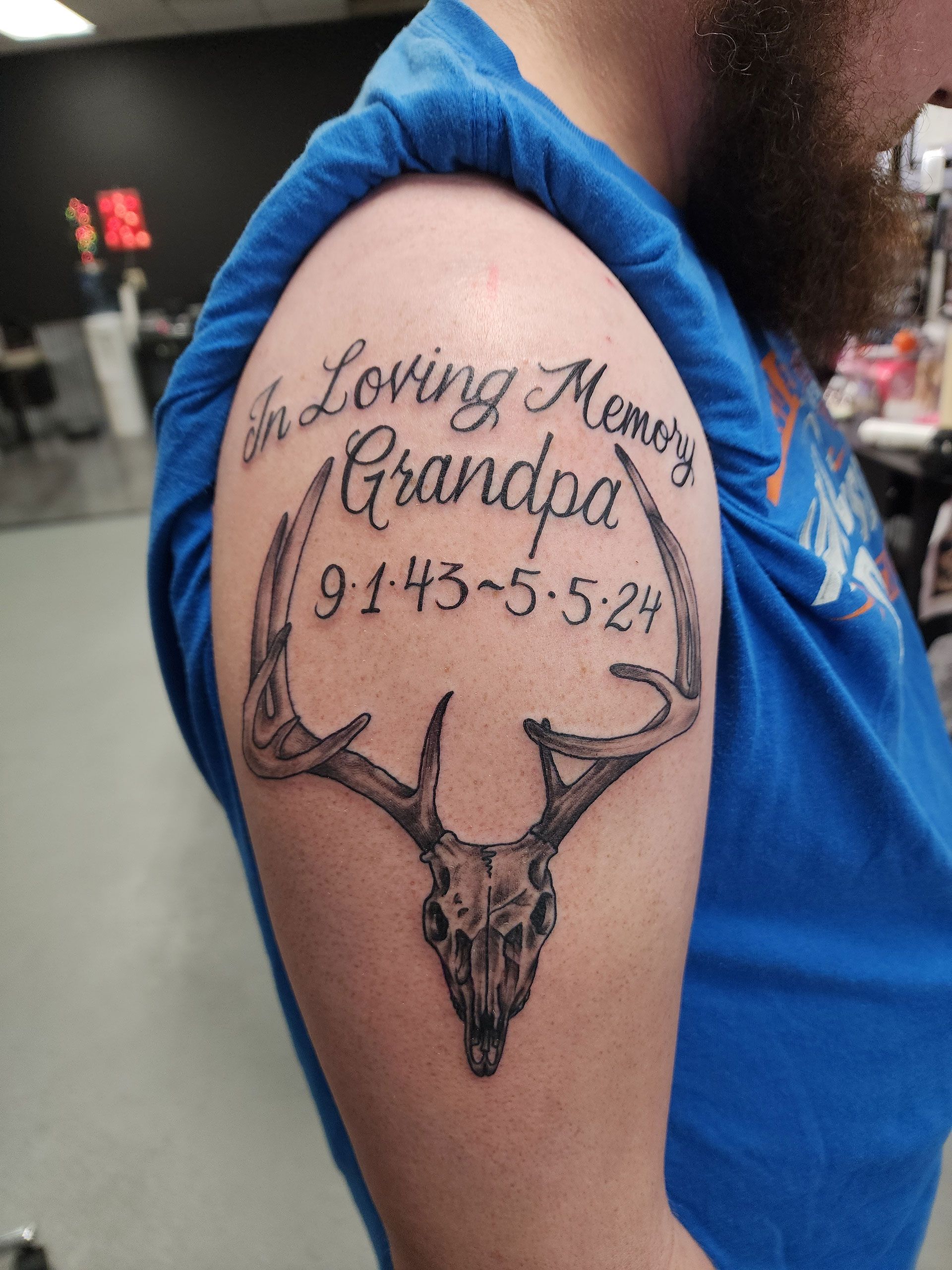 A man has a tattoo of a deer skull on his arm