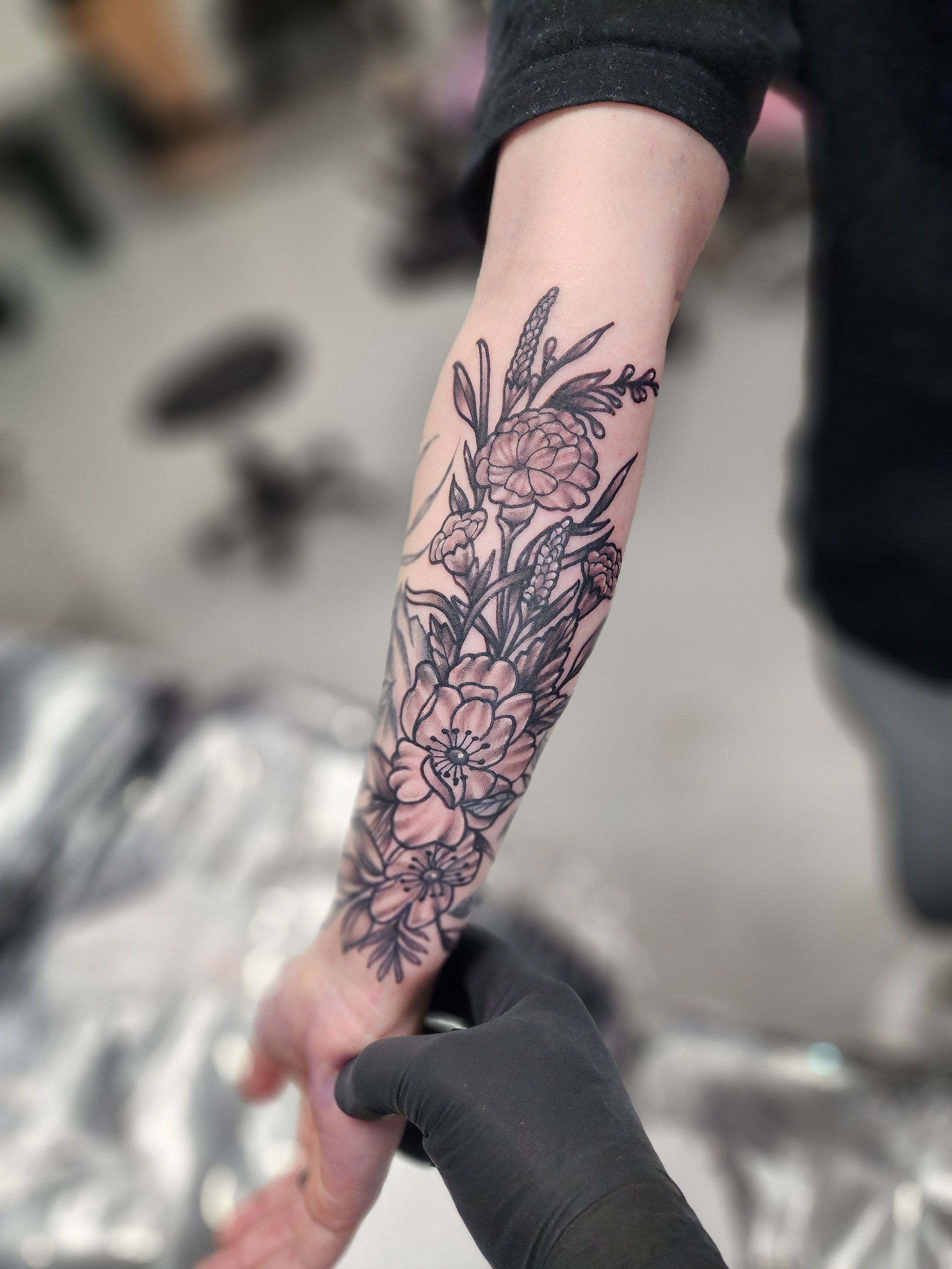 A person has a tattoo of flowers on their forearm