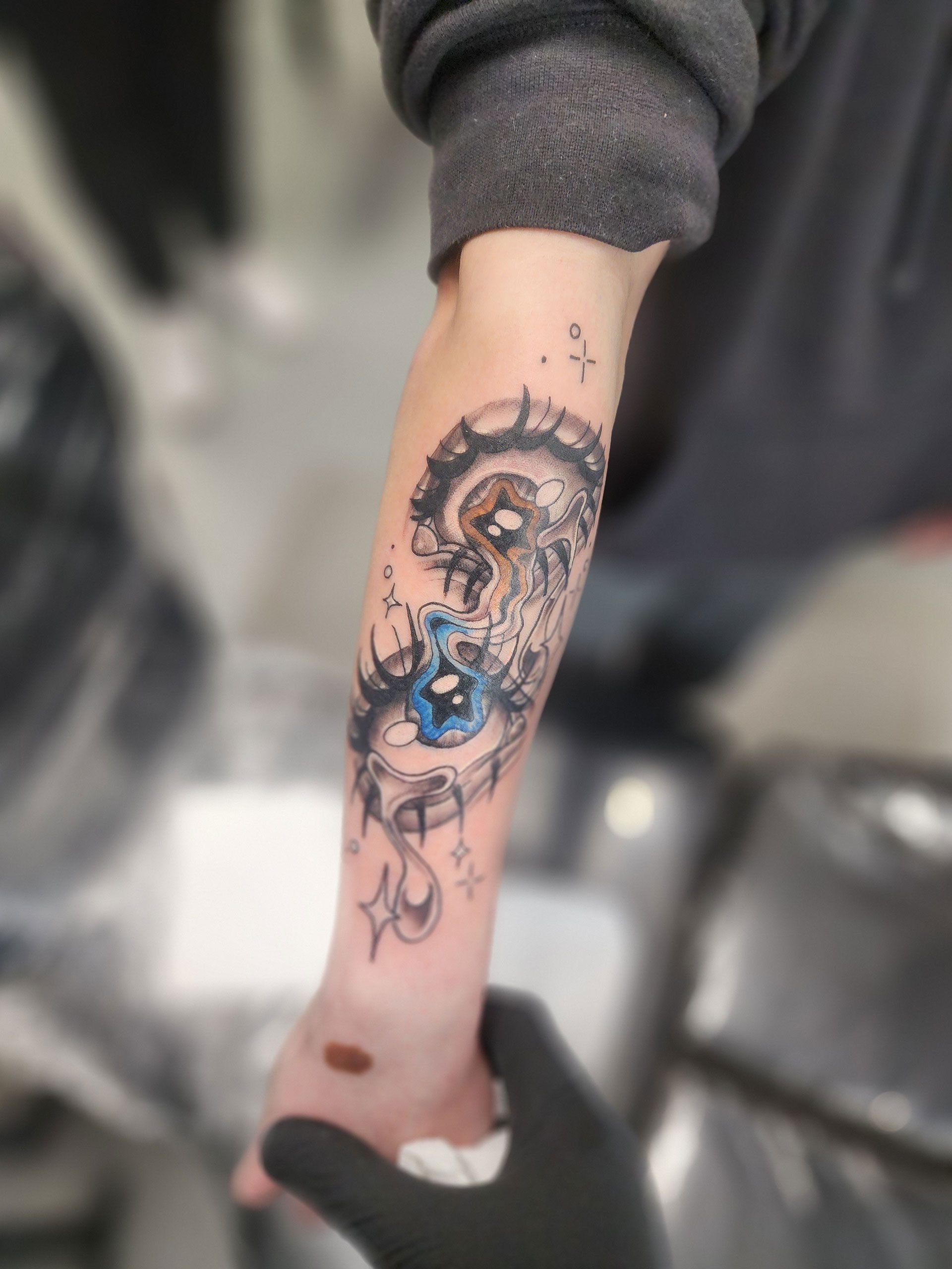 Artistic teary eyes tattoo on arm