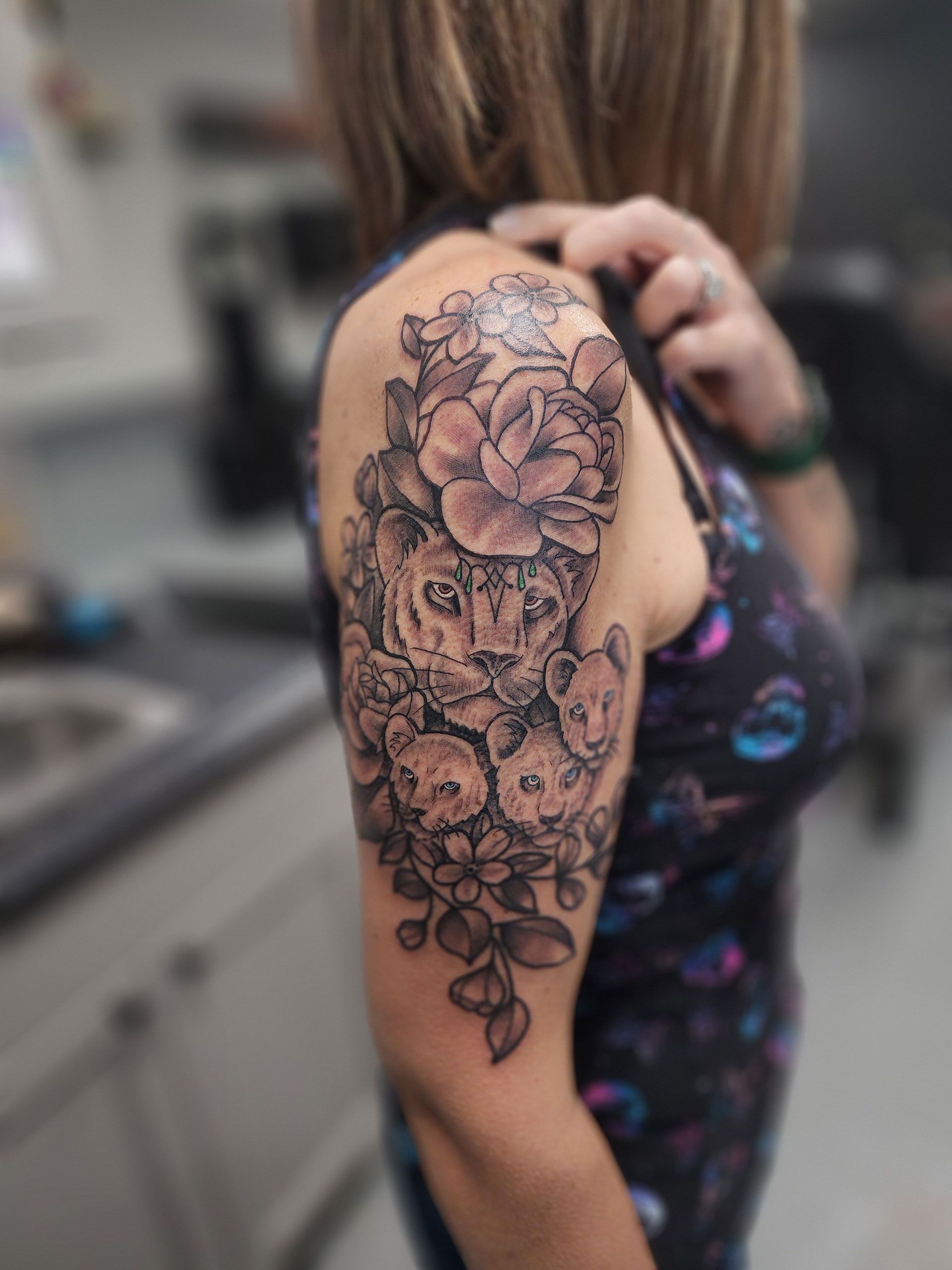 A woman has a tattoo of flowers on her shoulder