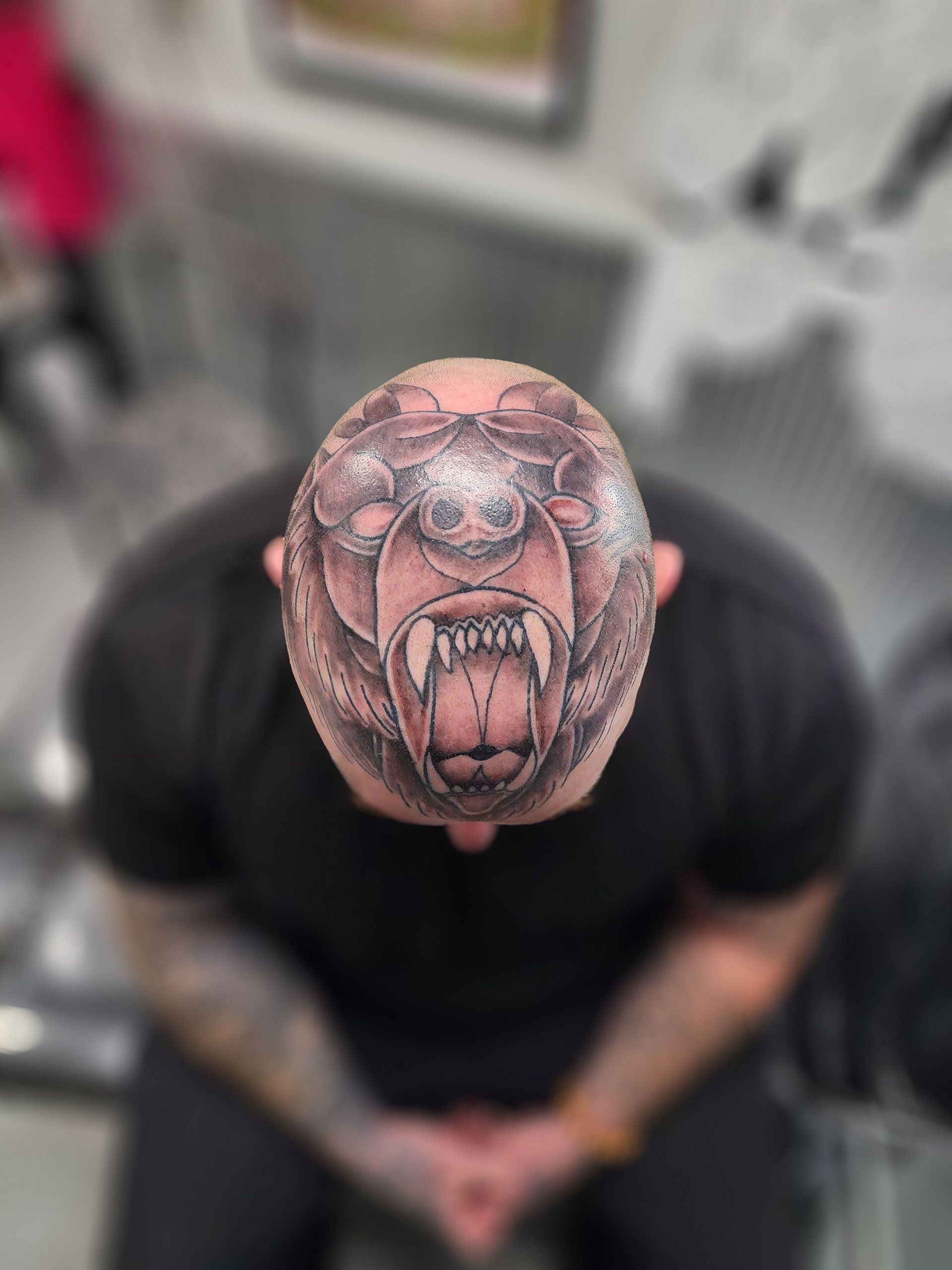 A man has a bear tattoo on his head