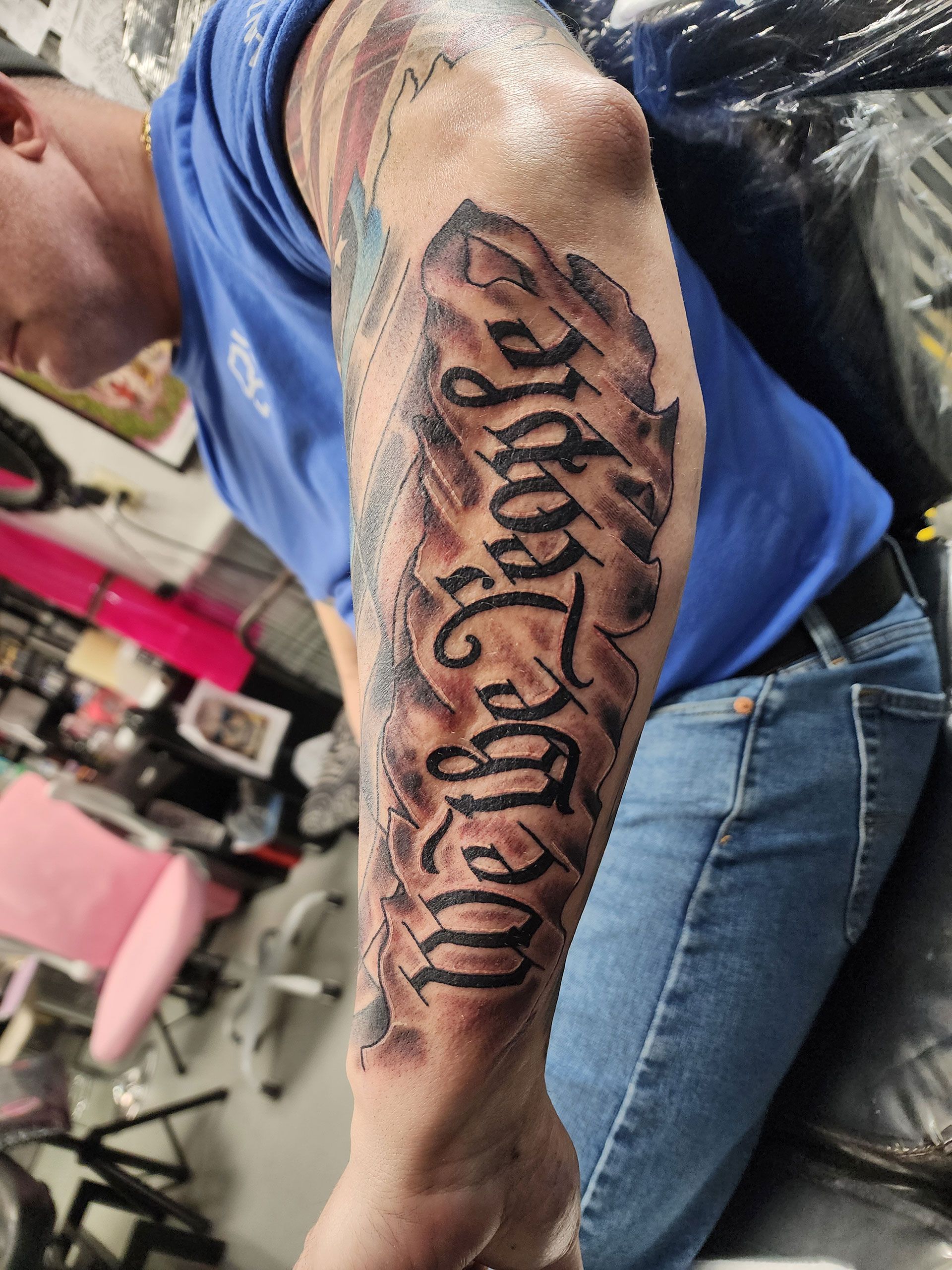 A man has a tattoo on his arm that says we the people