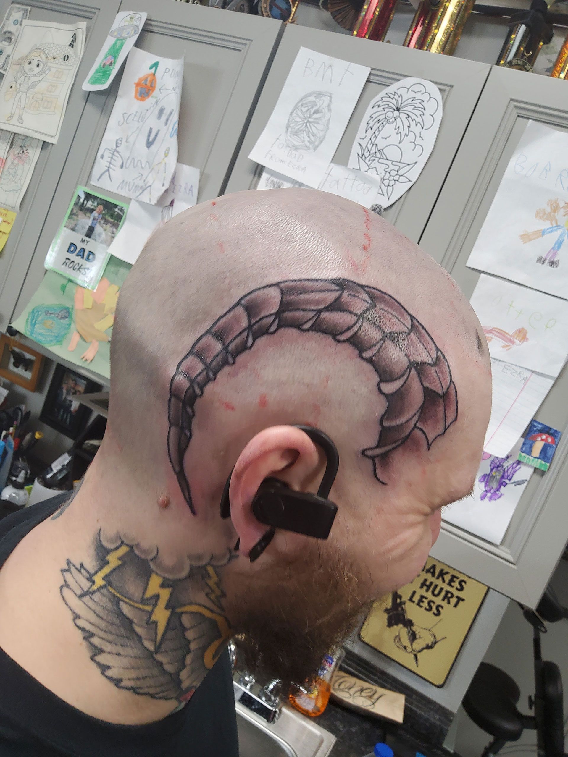 A man has a tattoo of a scorpion tail on his head