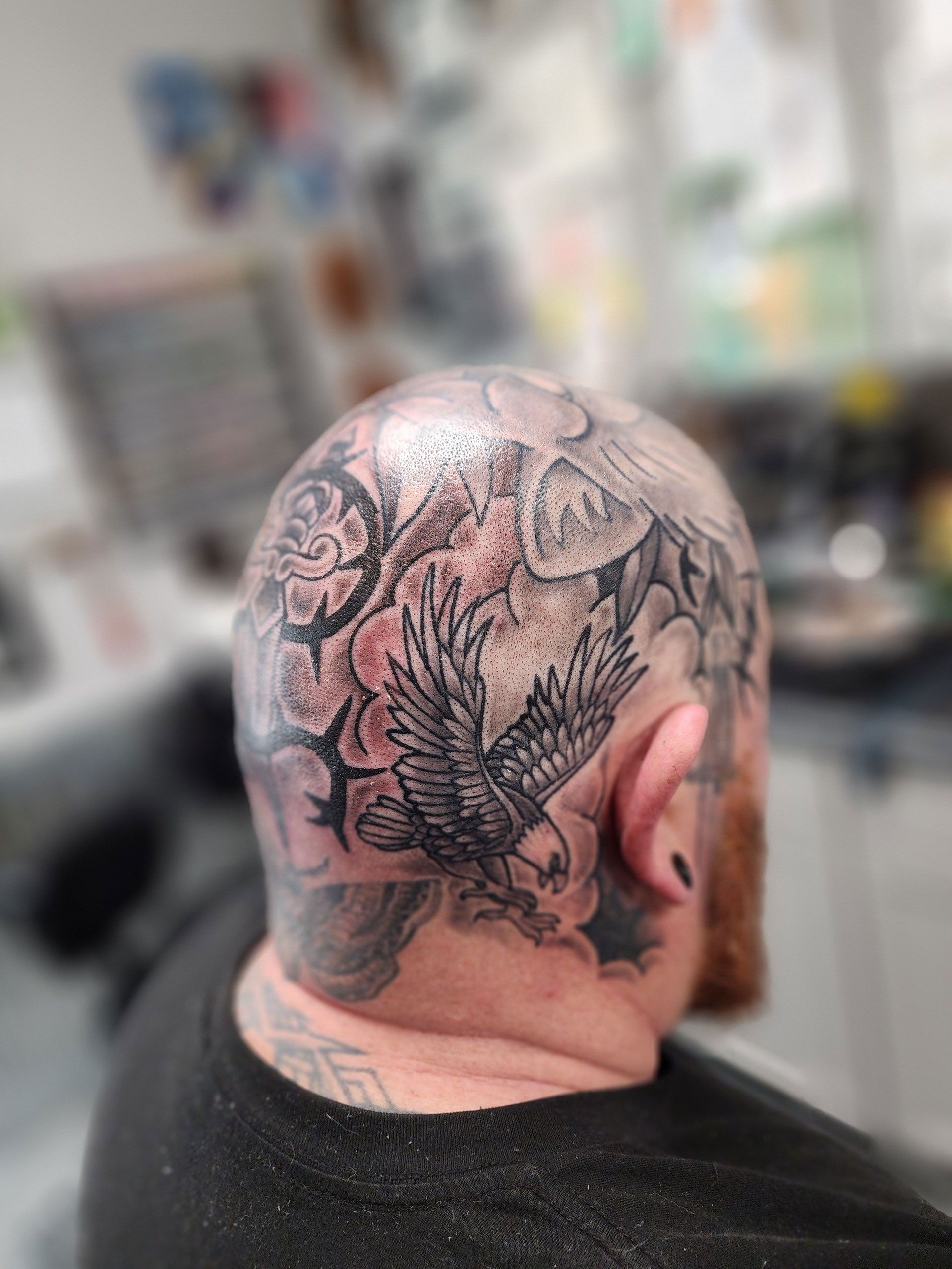 A man has a tattoo of an eagle on his head