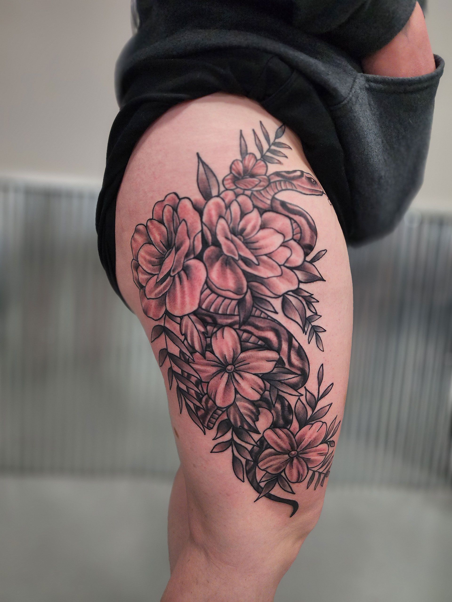 A woman has a tattoo of flowers on her leg