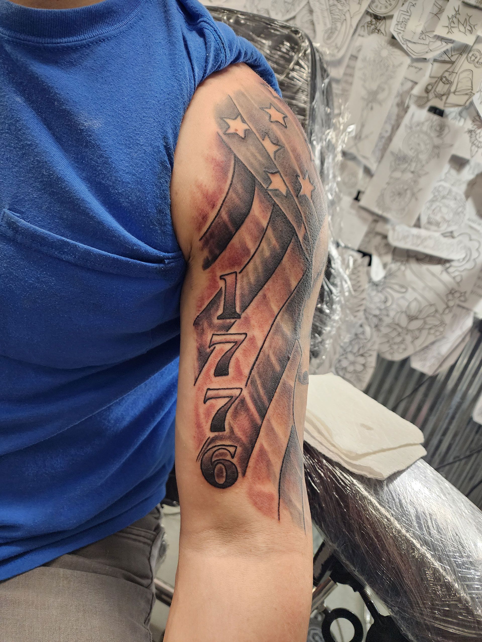 A man has a tattoo of an American flag on his arm