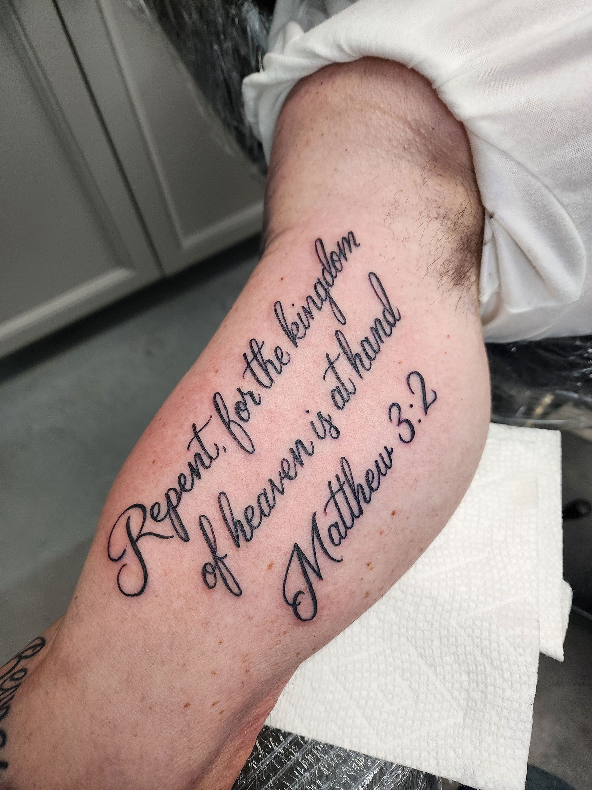 A man has a tattoo on his arm that says 