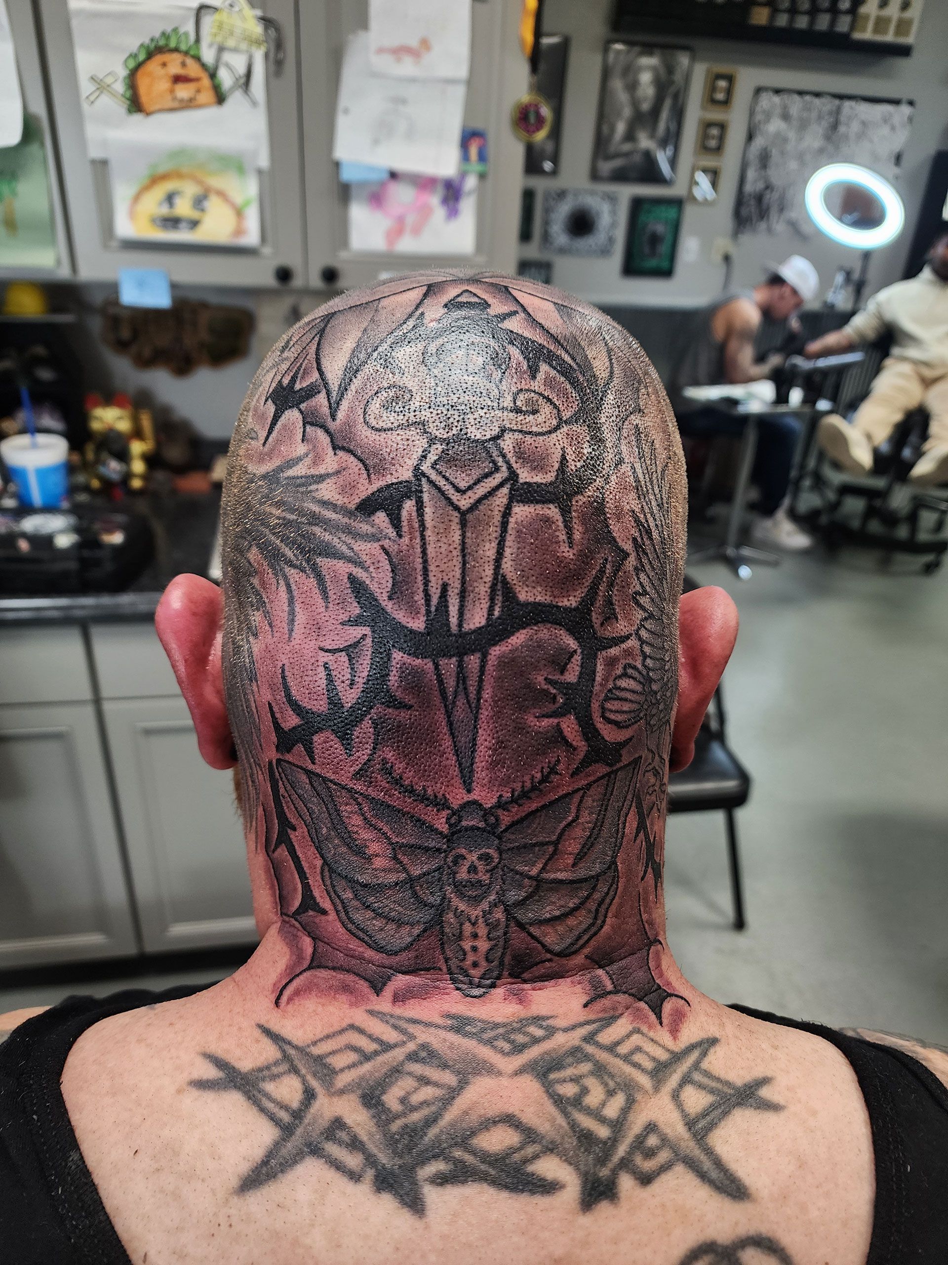 A man has a tattoo on his head and neck