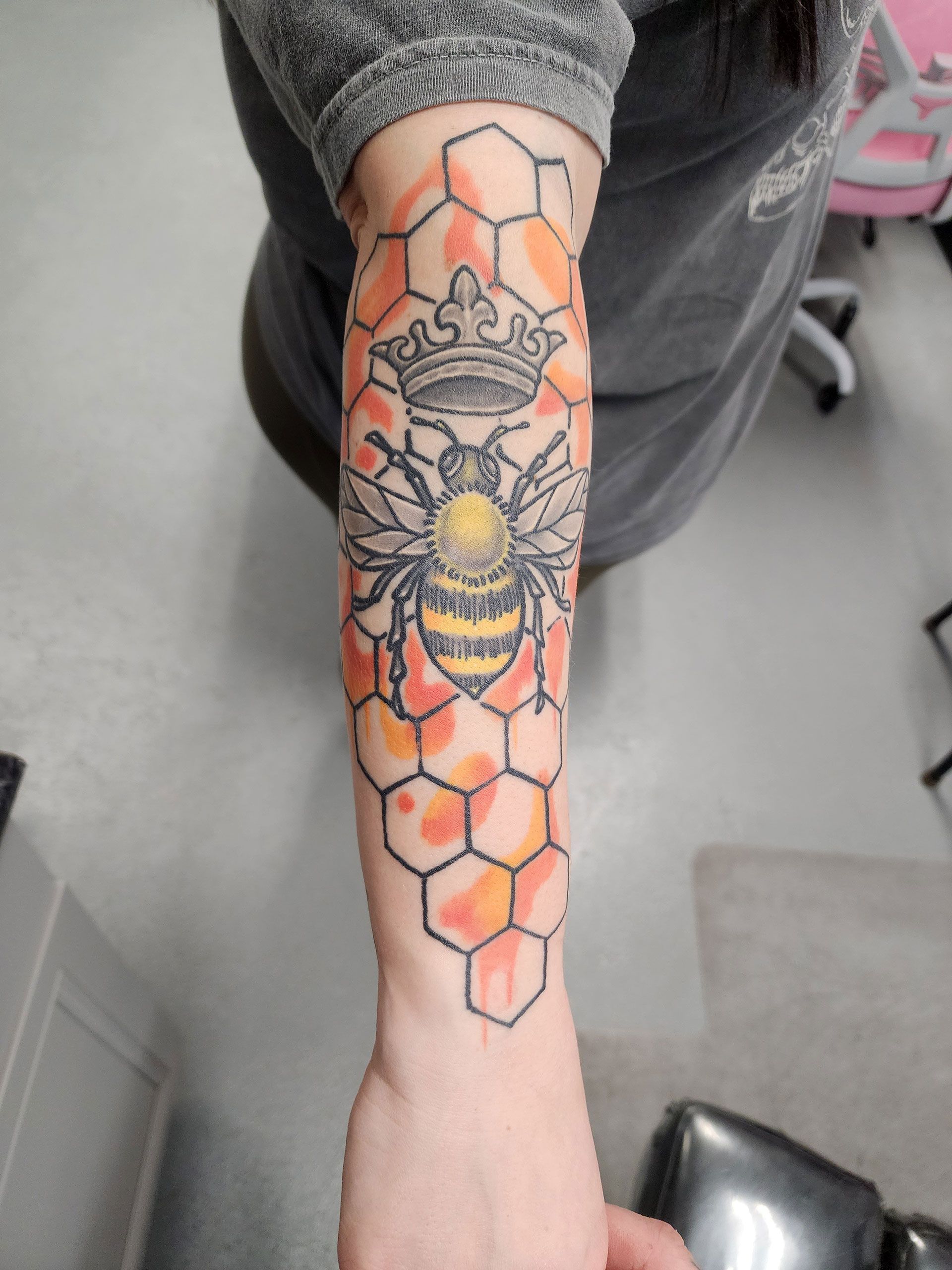 A woman has a tattoo of a bee on her arm.