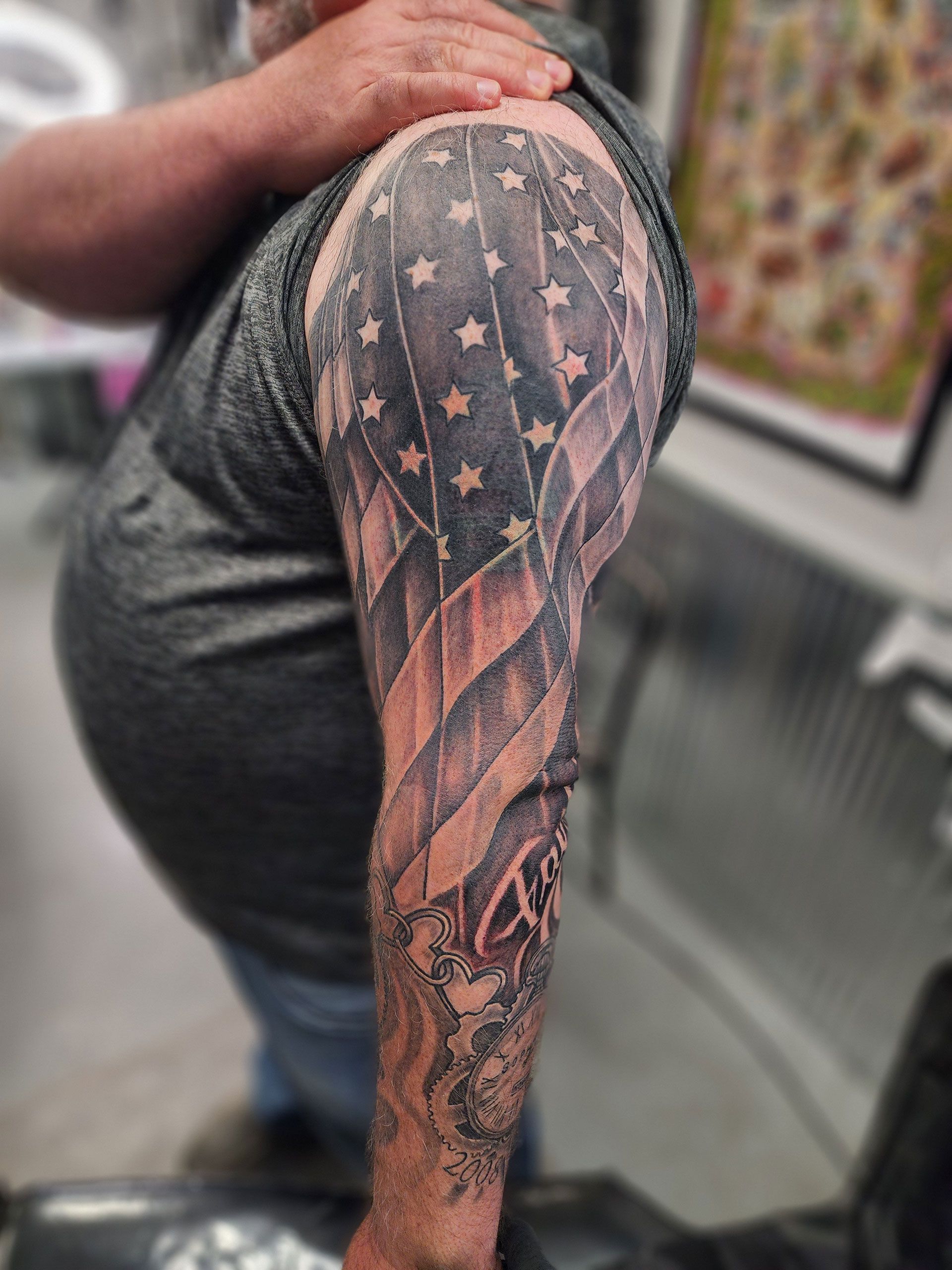 A man has a tattoo of an american flag on his arm