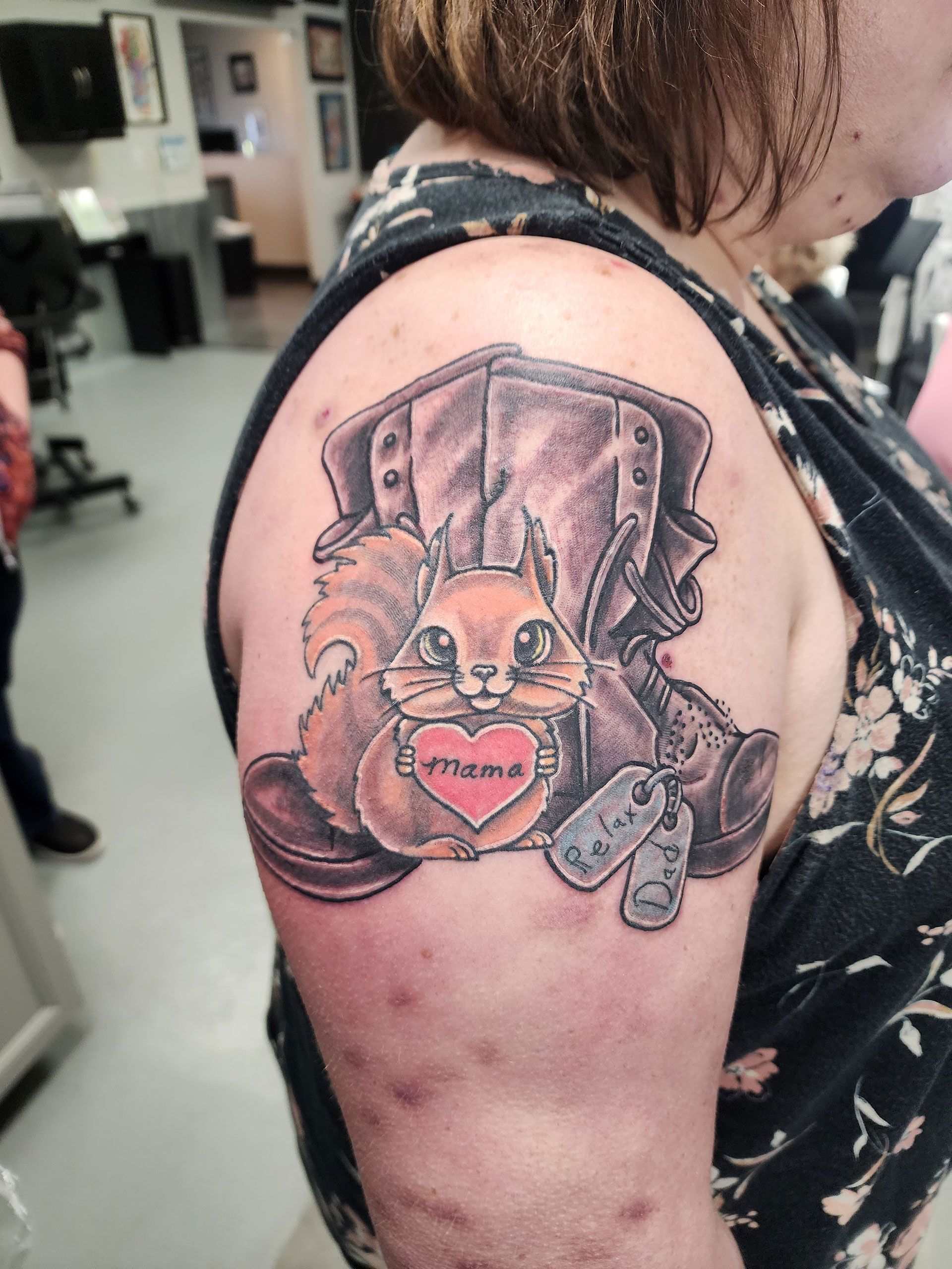 A woman has a tattoo of a squirrel holding a heart on her shoulder.