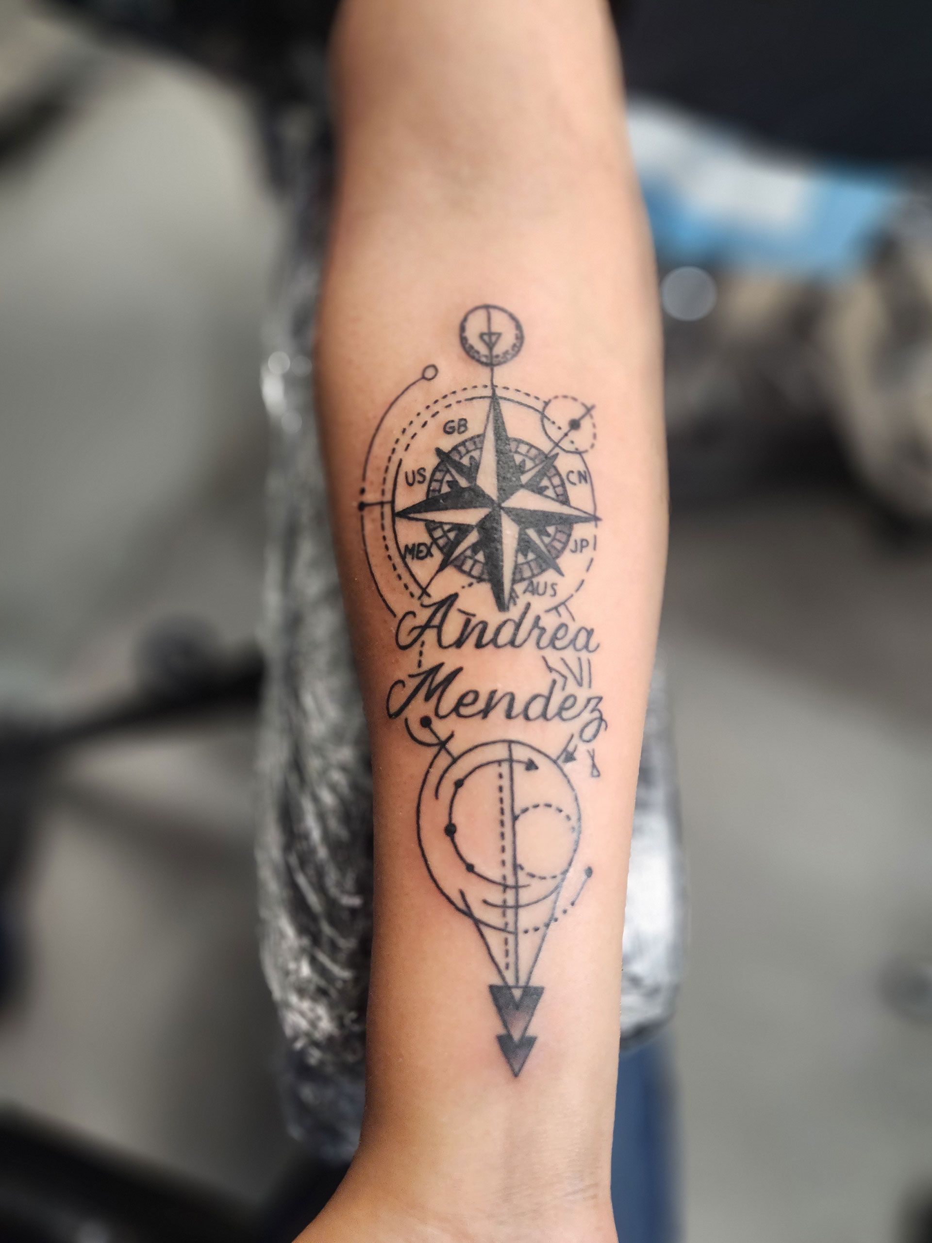A person has a tattoo on their forearm that says Andrea Mendez