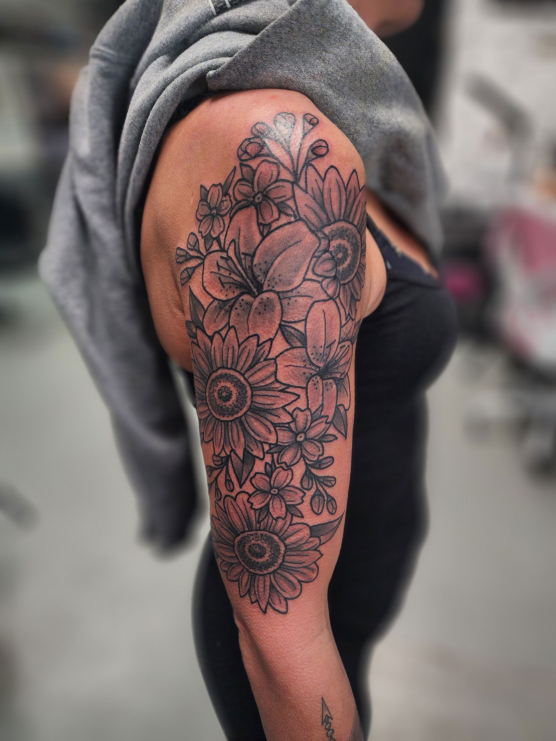 A woman has a tattoo of flowers on her arm