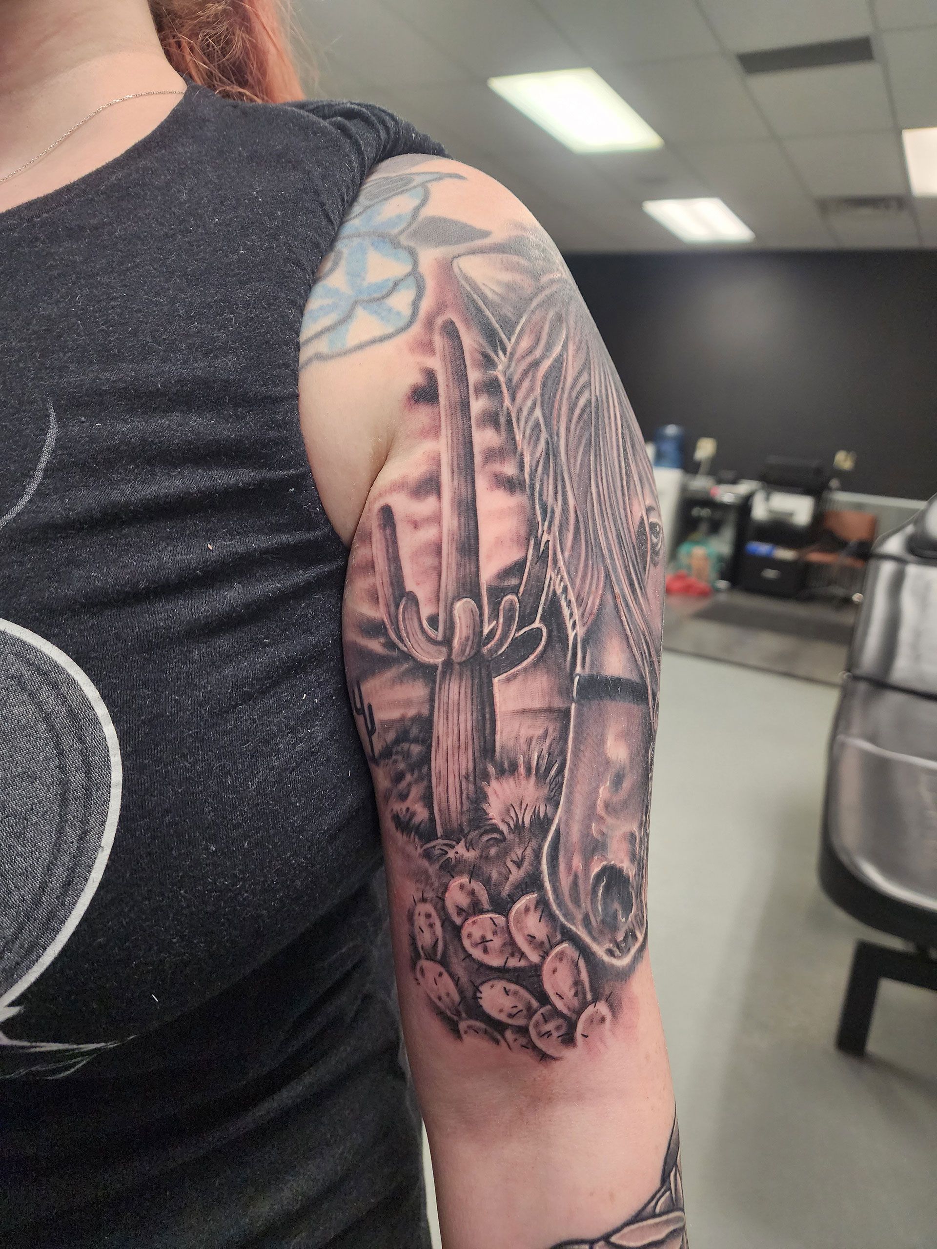 A woman has a tattoo of a cactus on her arm