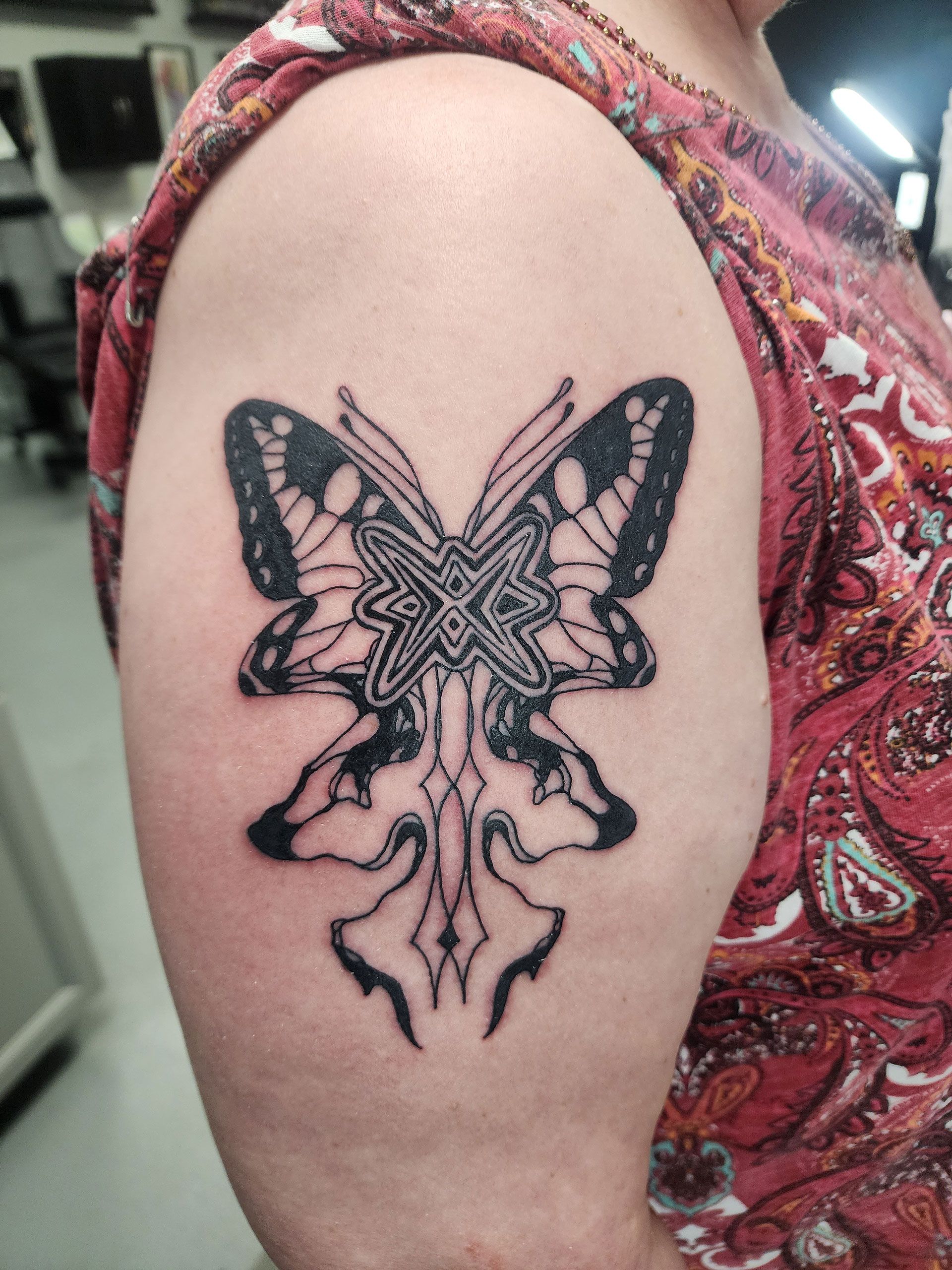 A woman has a tattoo of a butterfly on her arm