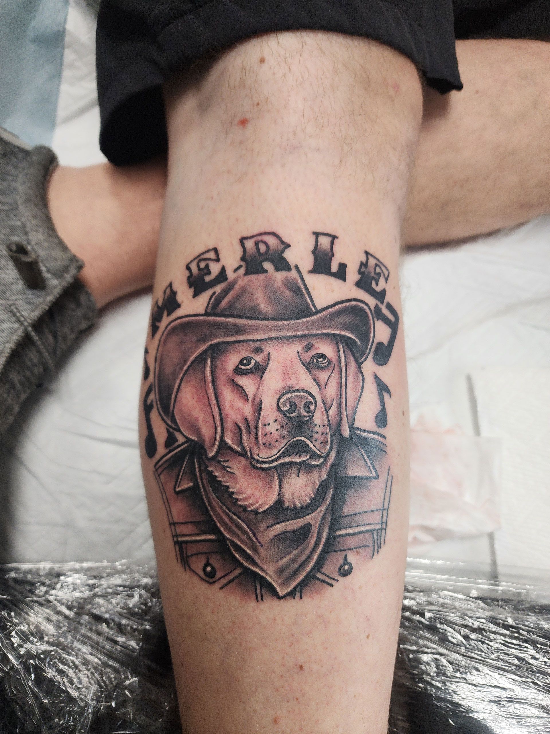 A tattoo of a dog wearing a cowboy hat