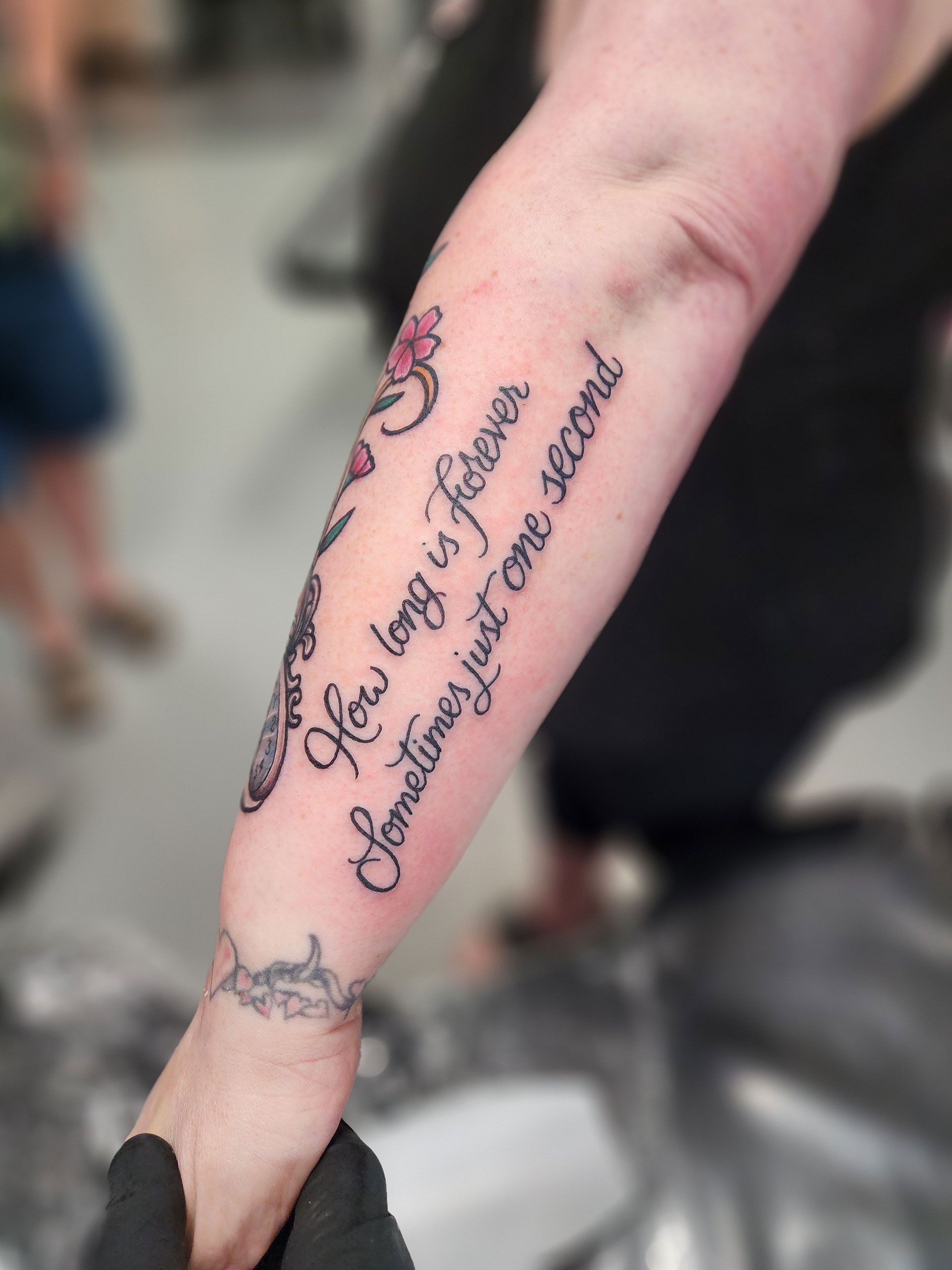 A woman has a tattoo on her arm that says 