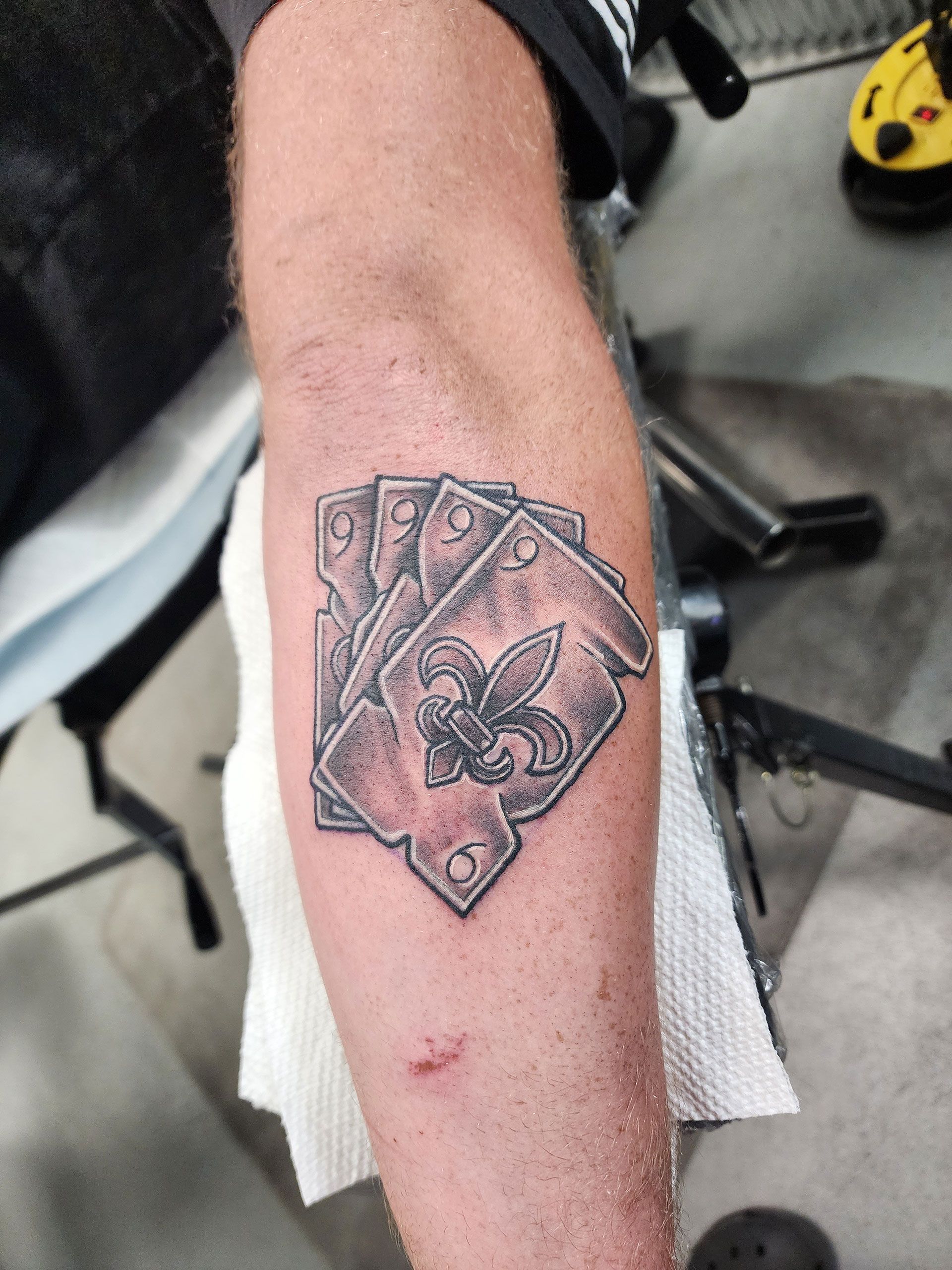 A man has a tattoo of playing cards on his arm