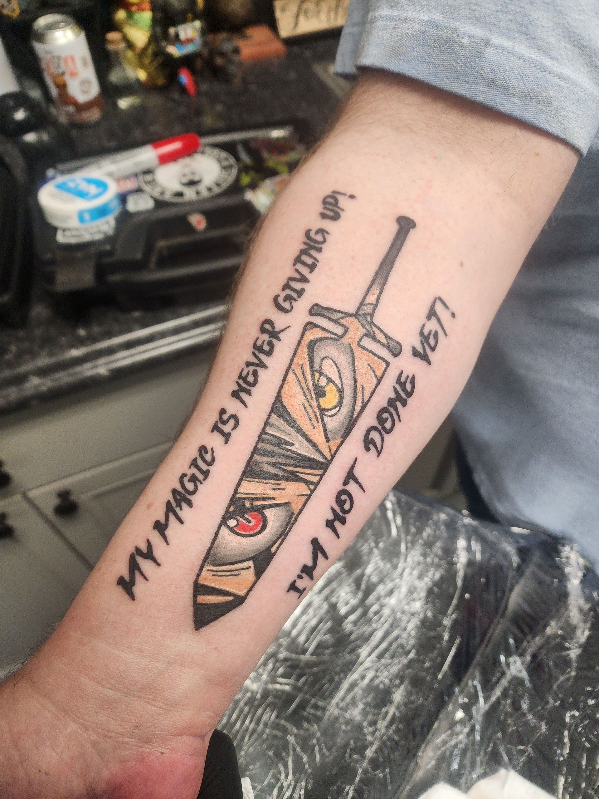 A person has a tattoo on their arm that says 