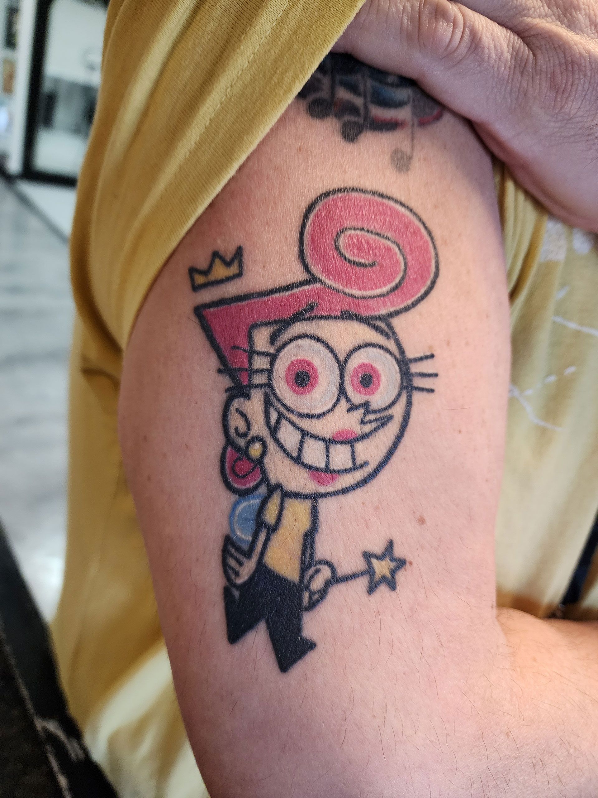A person has a tattoo of a cartoon character on their arm