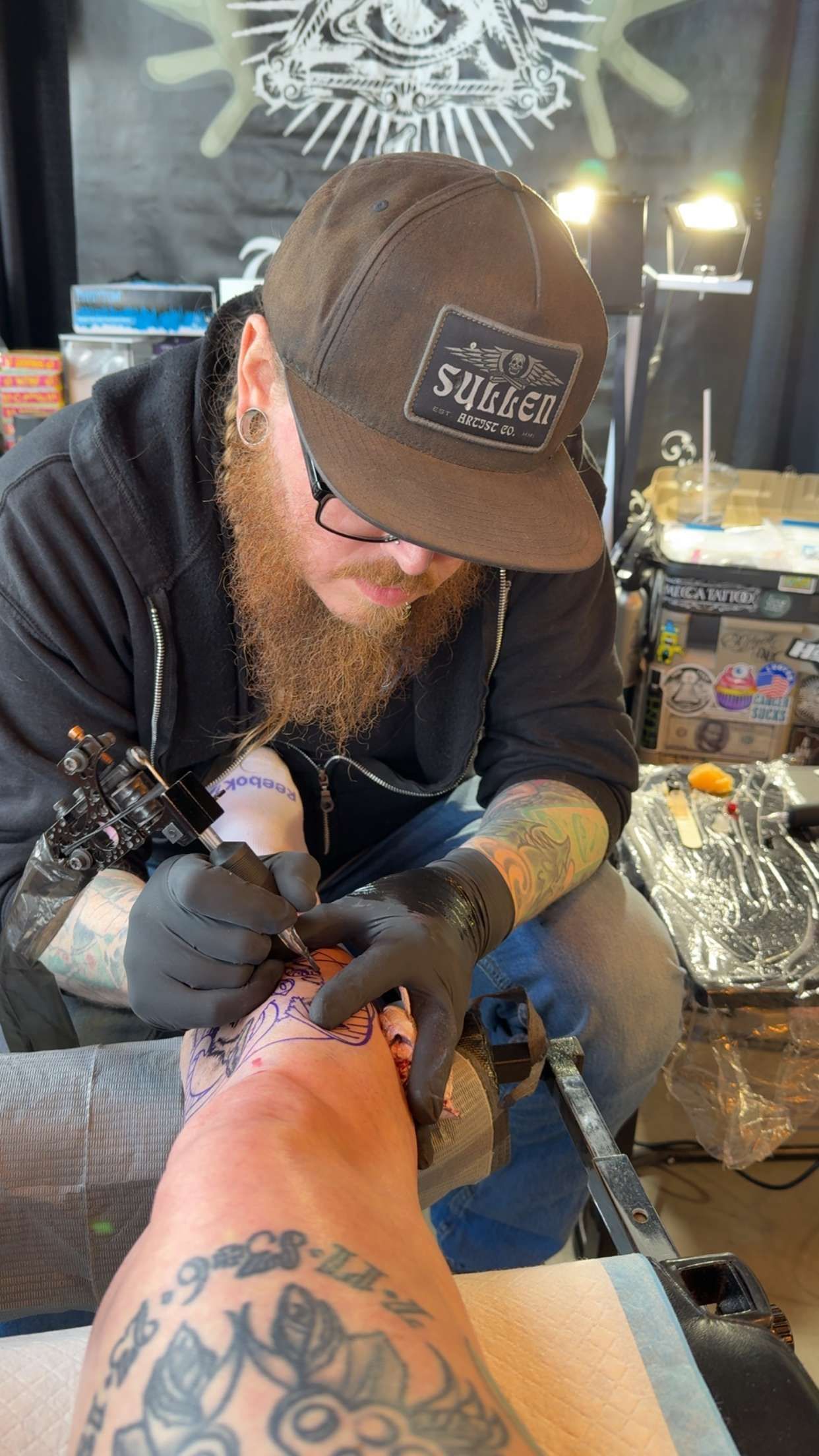 Isaac tattooing a client's leg