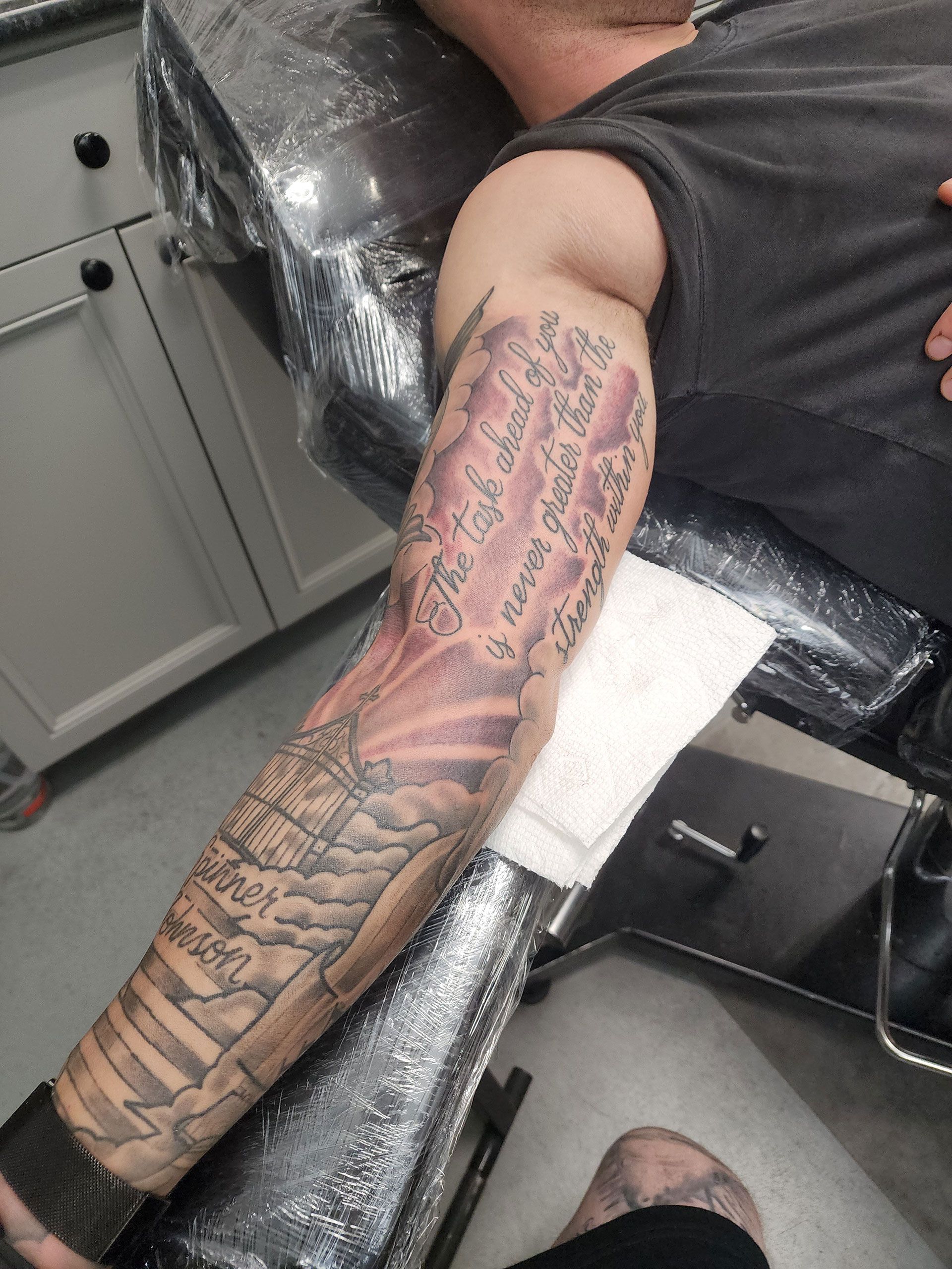 A man is getting a tattoo on his arm