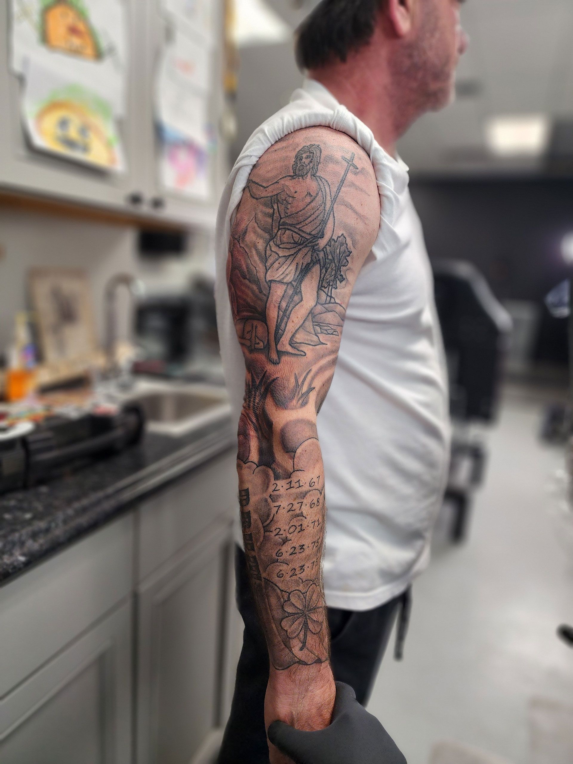 A man with a full sleeve tattoo on his arm