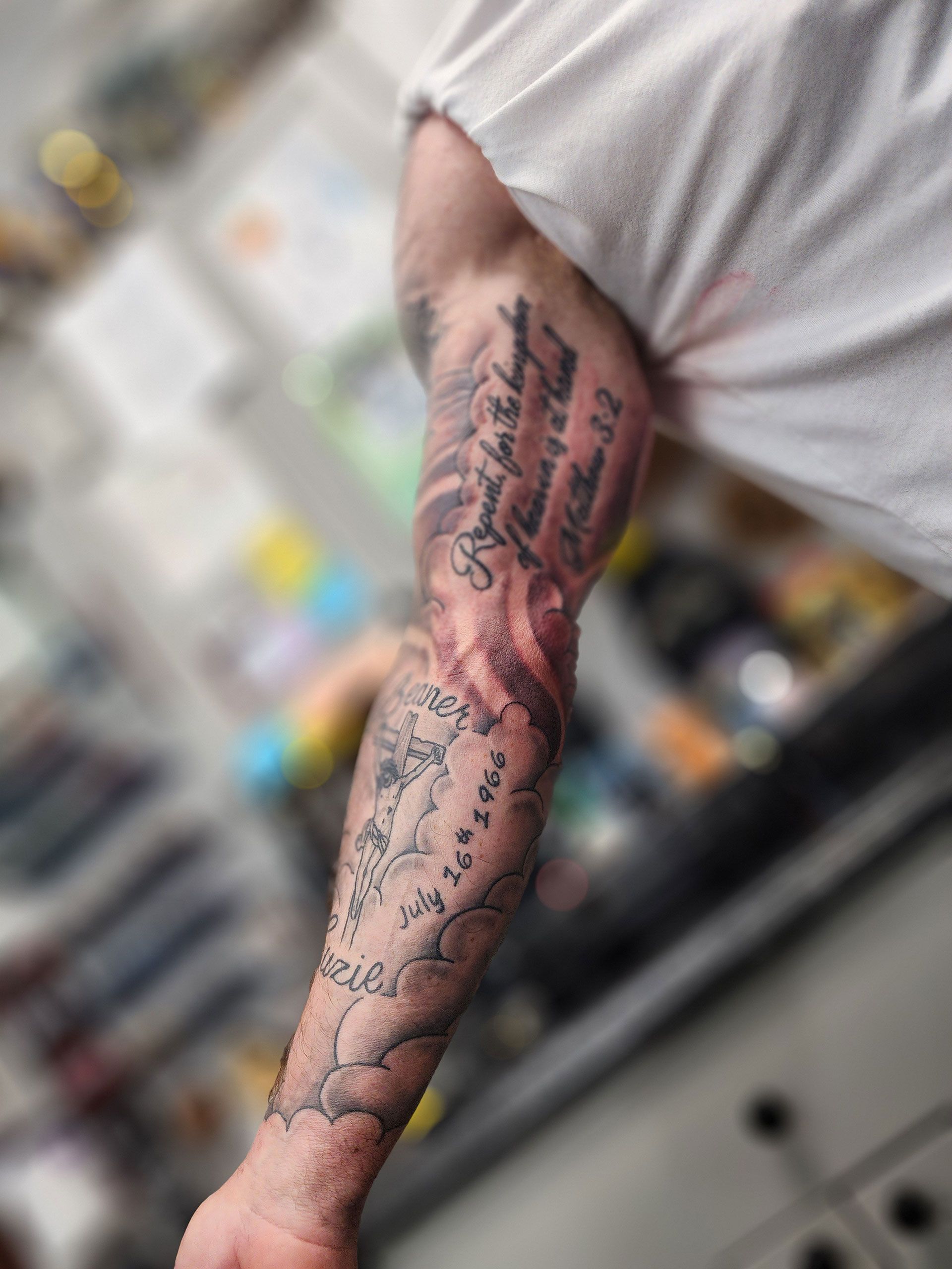 A man with a crucifix tattoo on his arm
