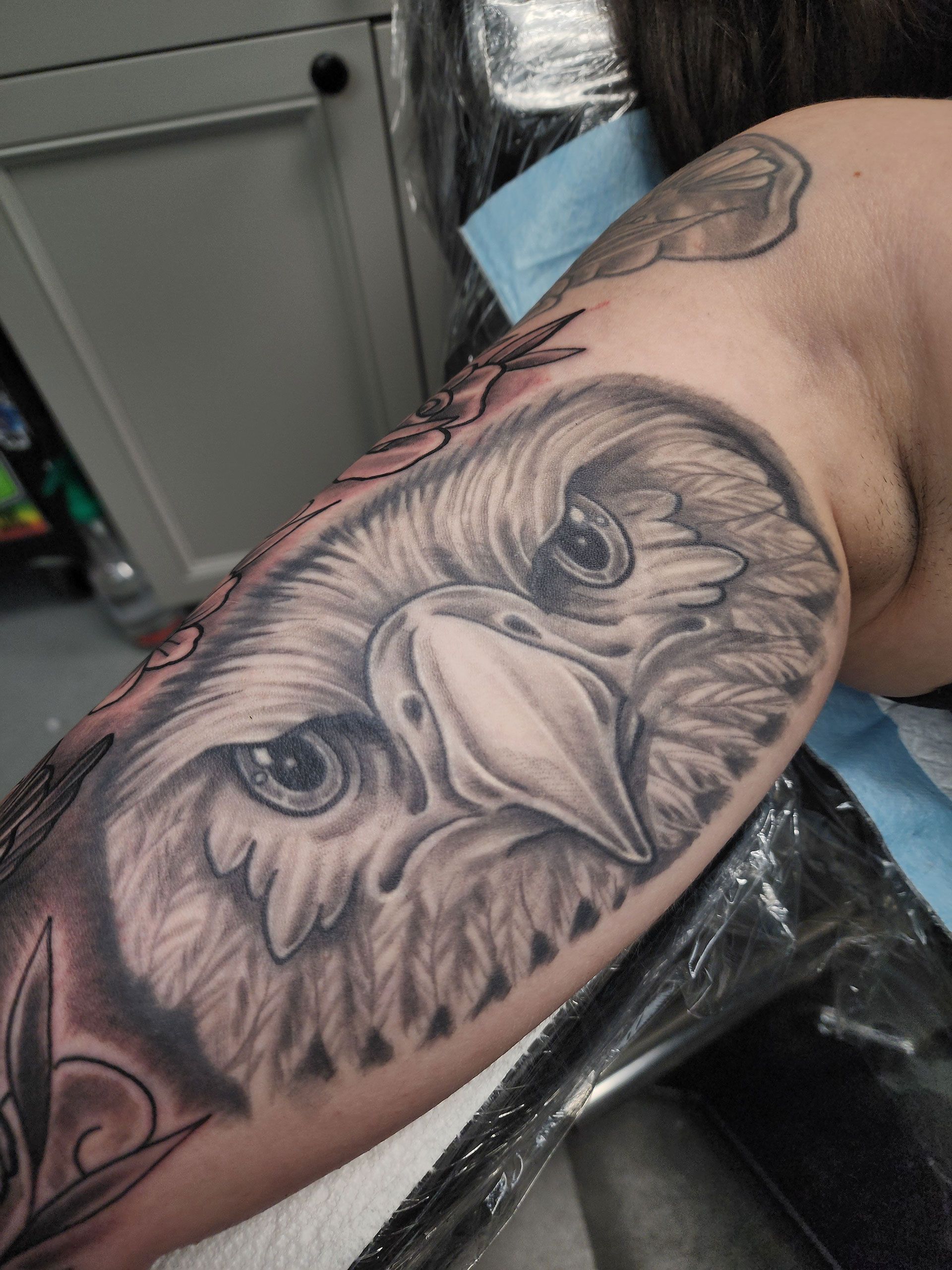 A person has a tattoo of an eagle on their arm