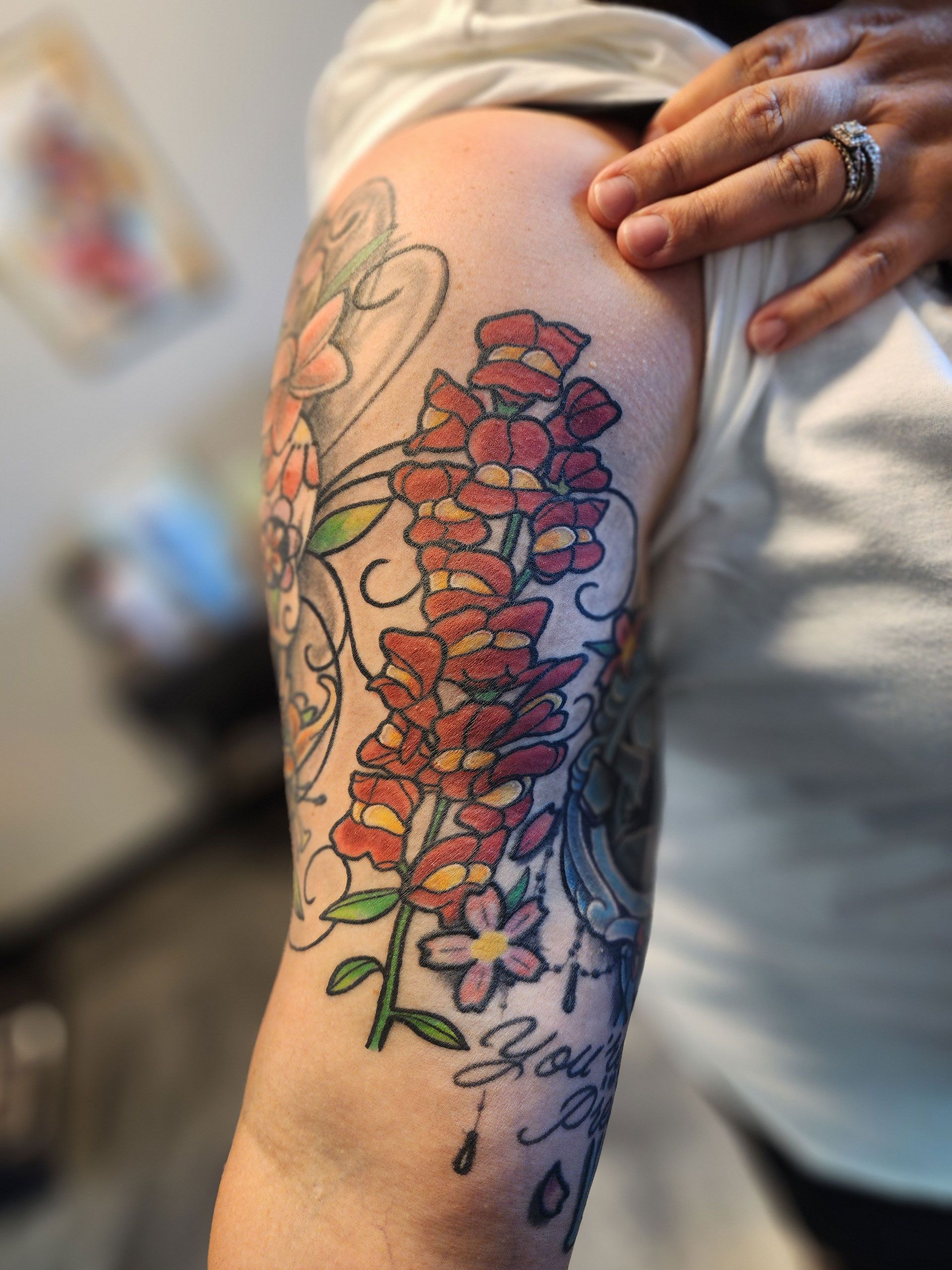A woman has a tattoo of flowers on her arm