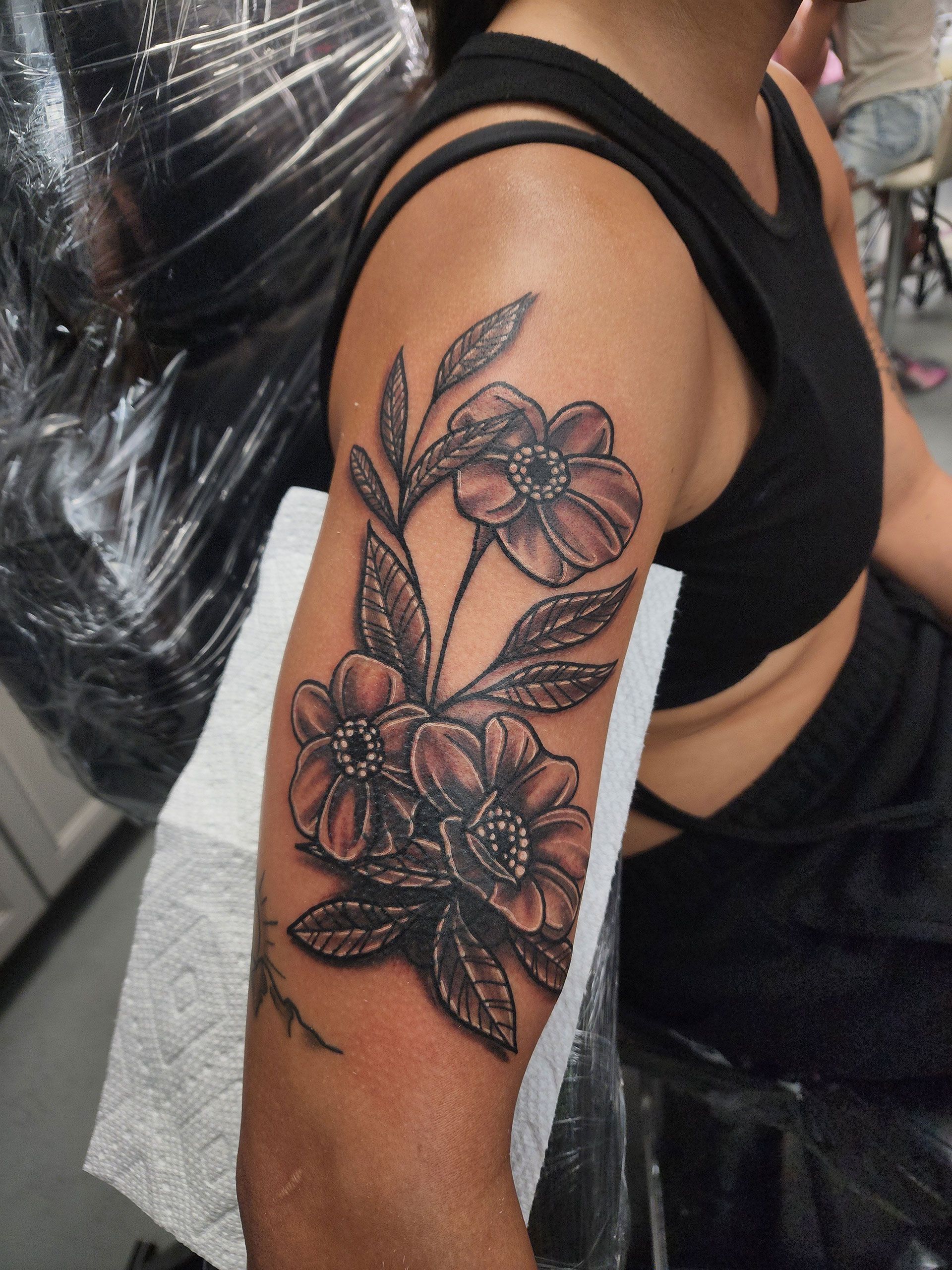 A woman has a tattoo of flowers on her arm