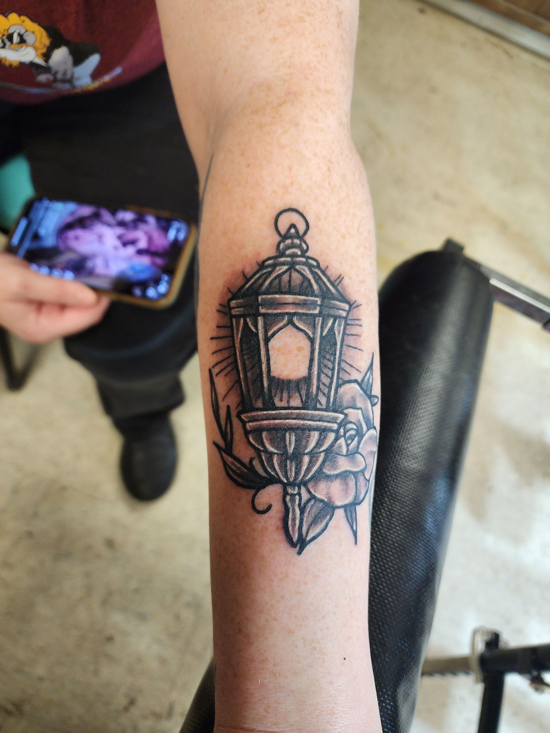 A person has a tattoo of a lantern on their arm