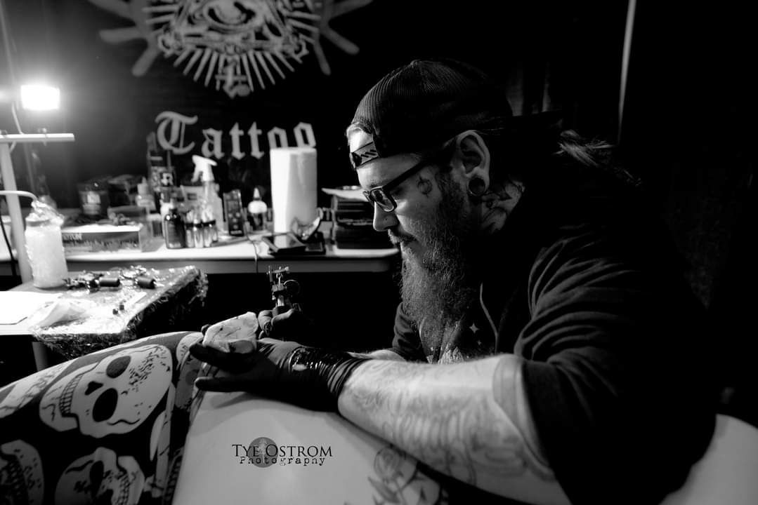 Isaac tattooing back of a client