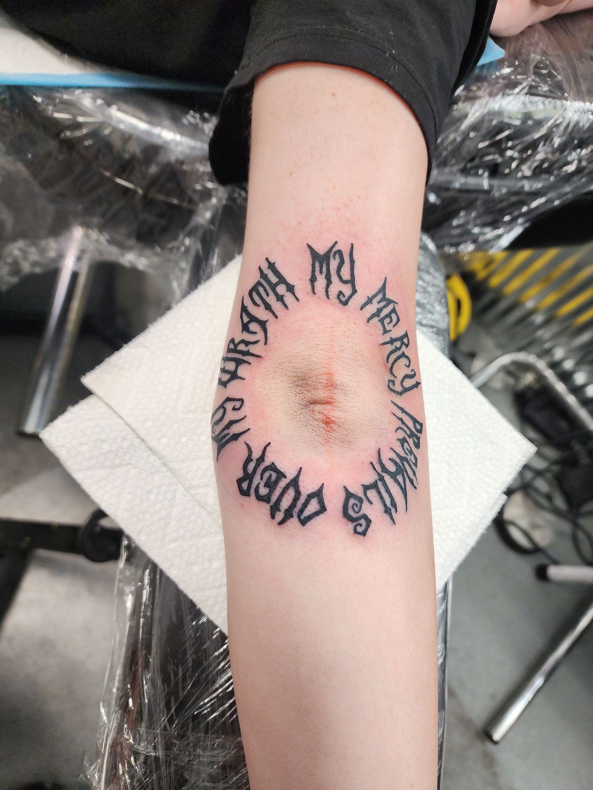 A person has a tattoo on their elbow that says 