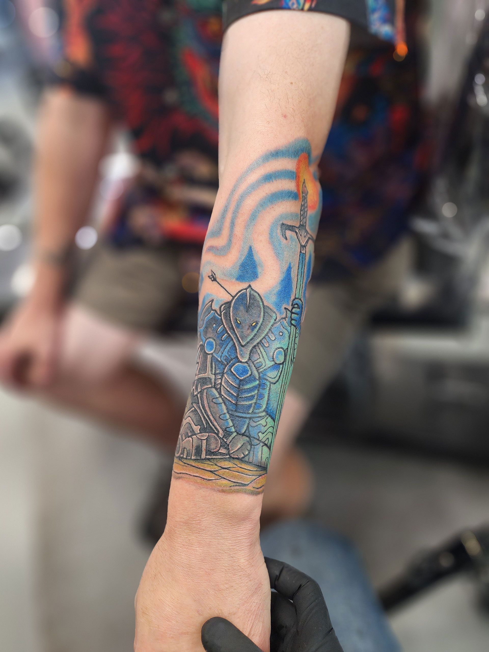 A person has a tattoo of a soldier with sword on their arm