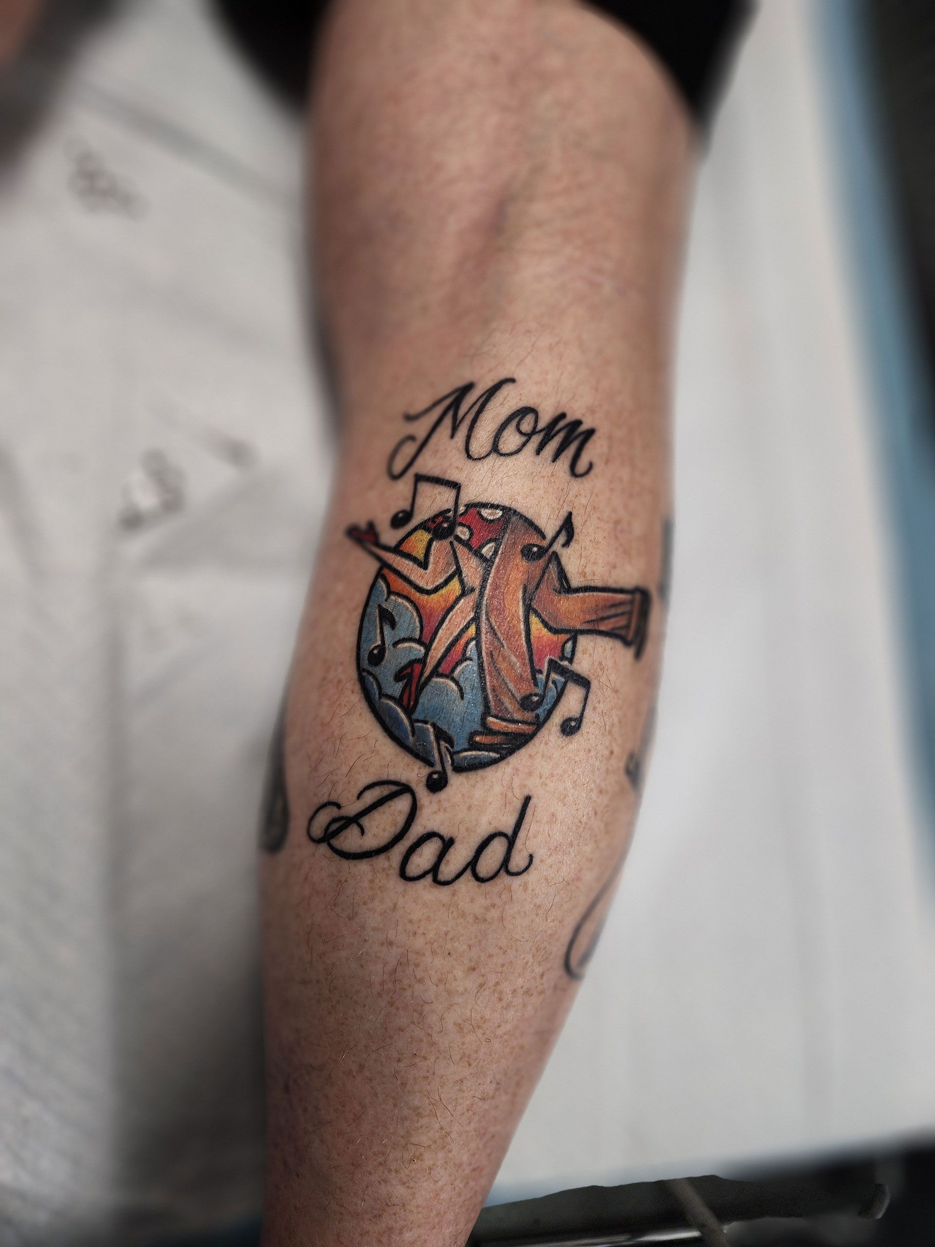 A tattoo on a person's arm that says mom and dad