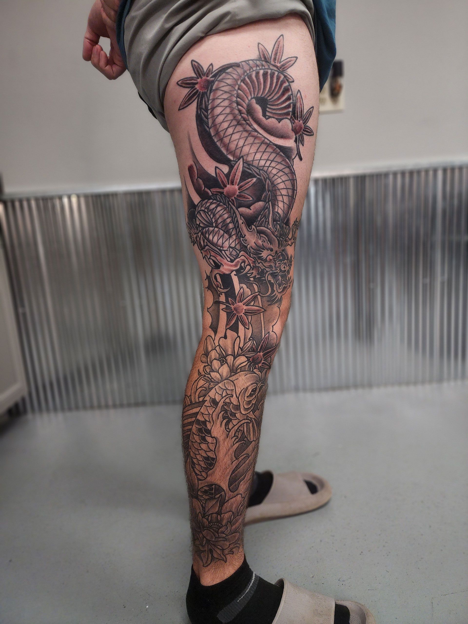A person with a dragon tattoo on their leg