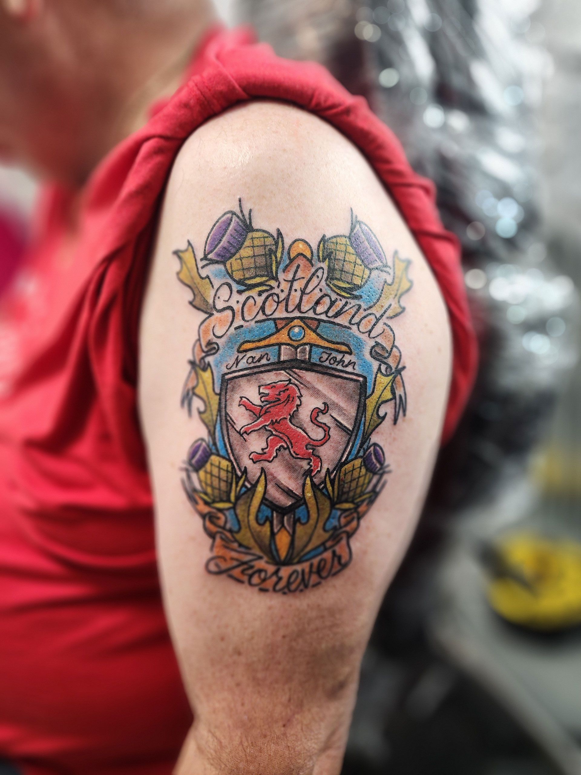 A man has a tattoo on his arm that says Scotland