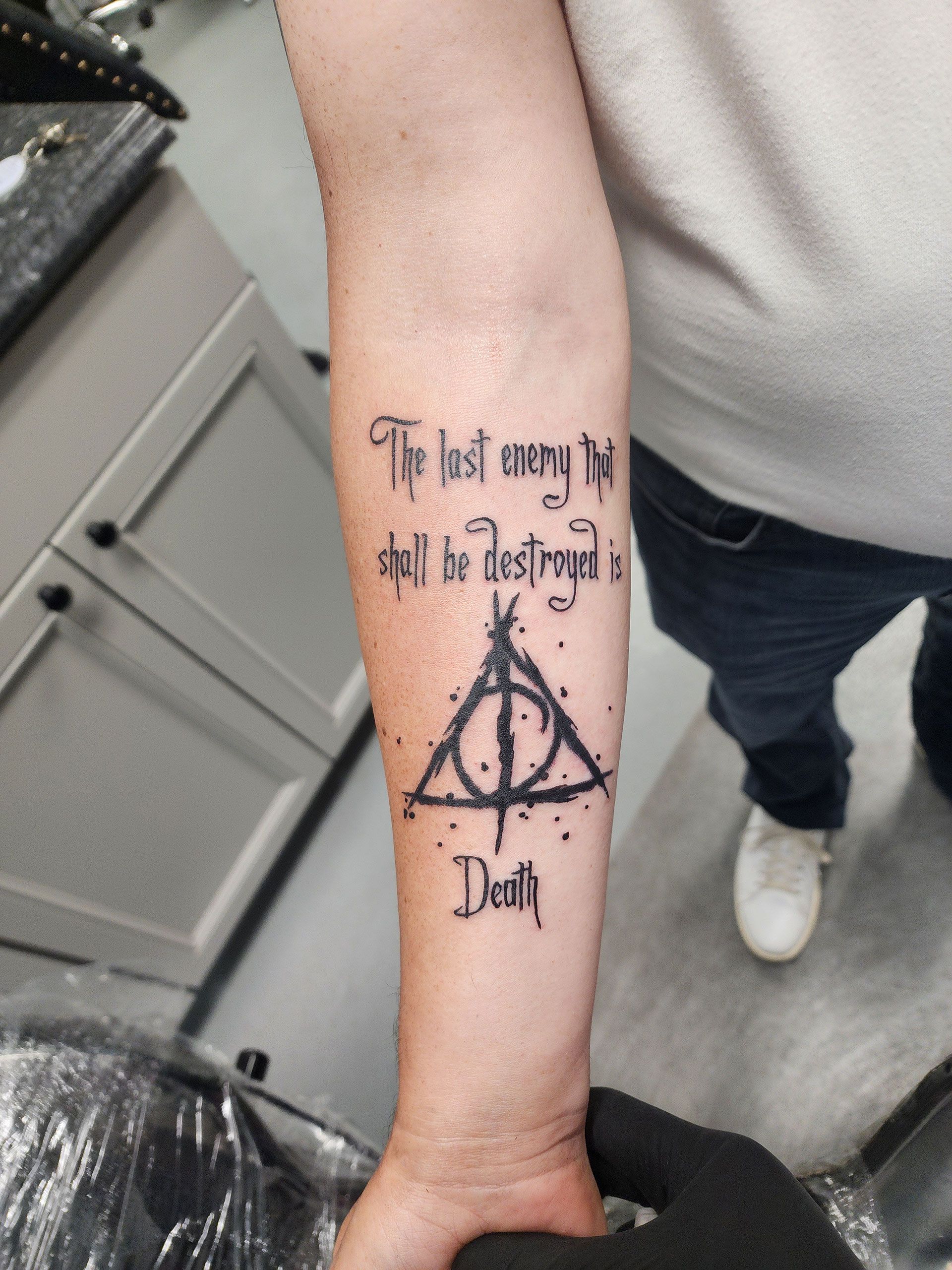 A man has a Harry Potter tattoo on his forearm