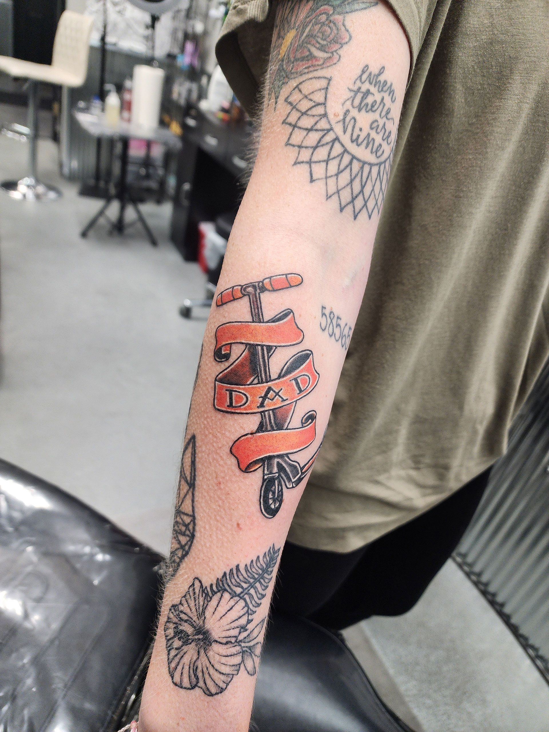 Scooter with the word DAD on ribbon tattoo