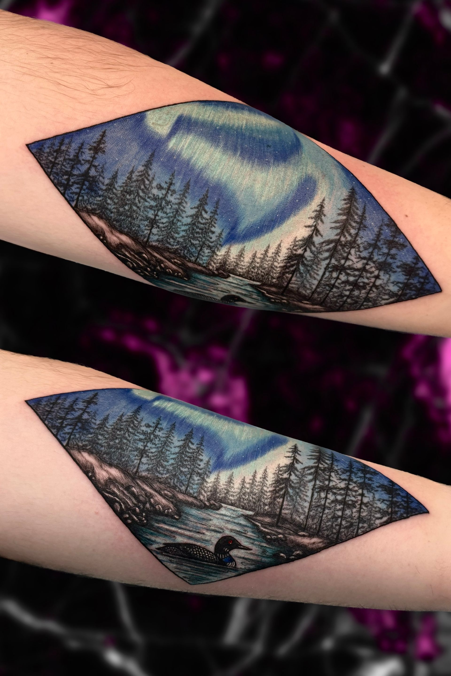 A tattoo of the aurora borealis over a forest on a persons forearm
