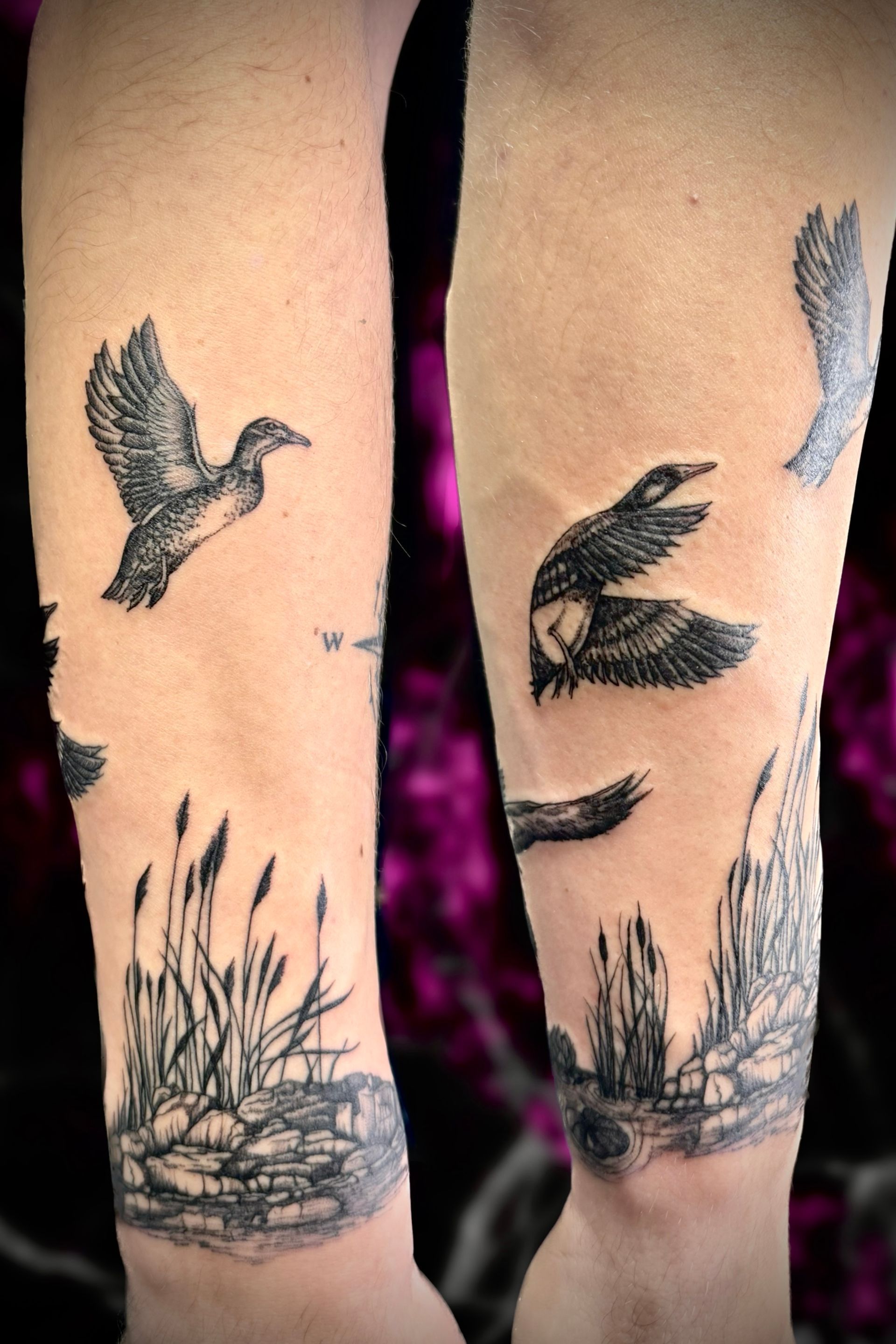 A person has a tattoo of birds flying over a body of water