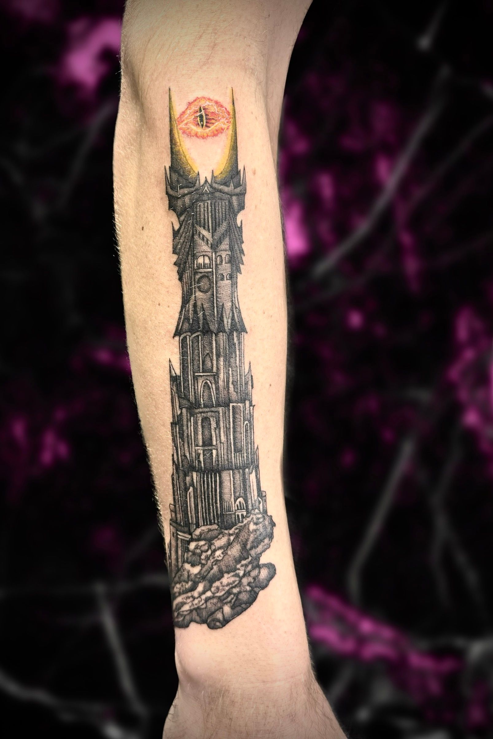 A person has a tattoo of a tower on their arms